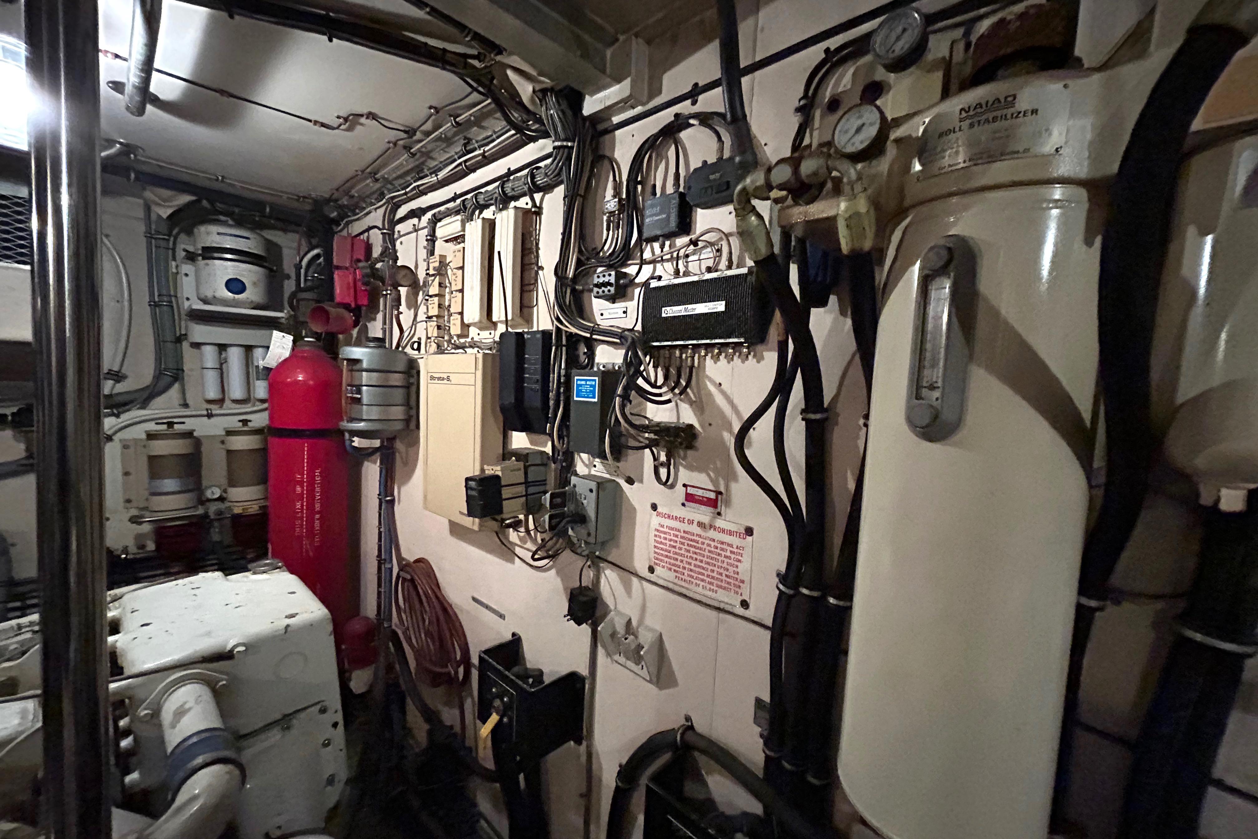 Engine room of a 1991 Hatteras Cockpit Motor Yacht with various equipment and machinery.
