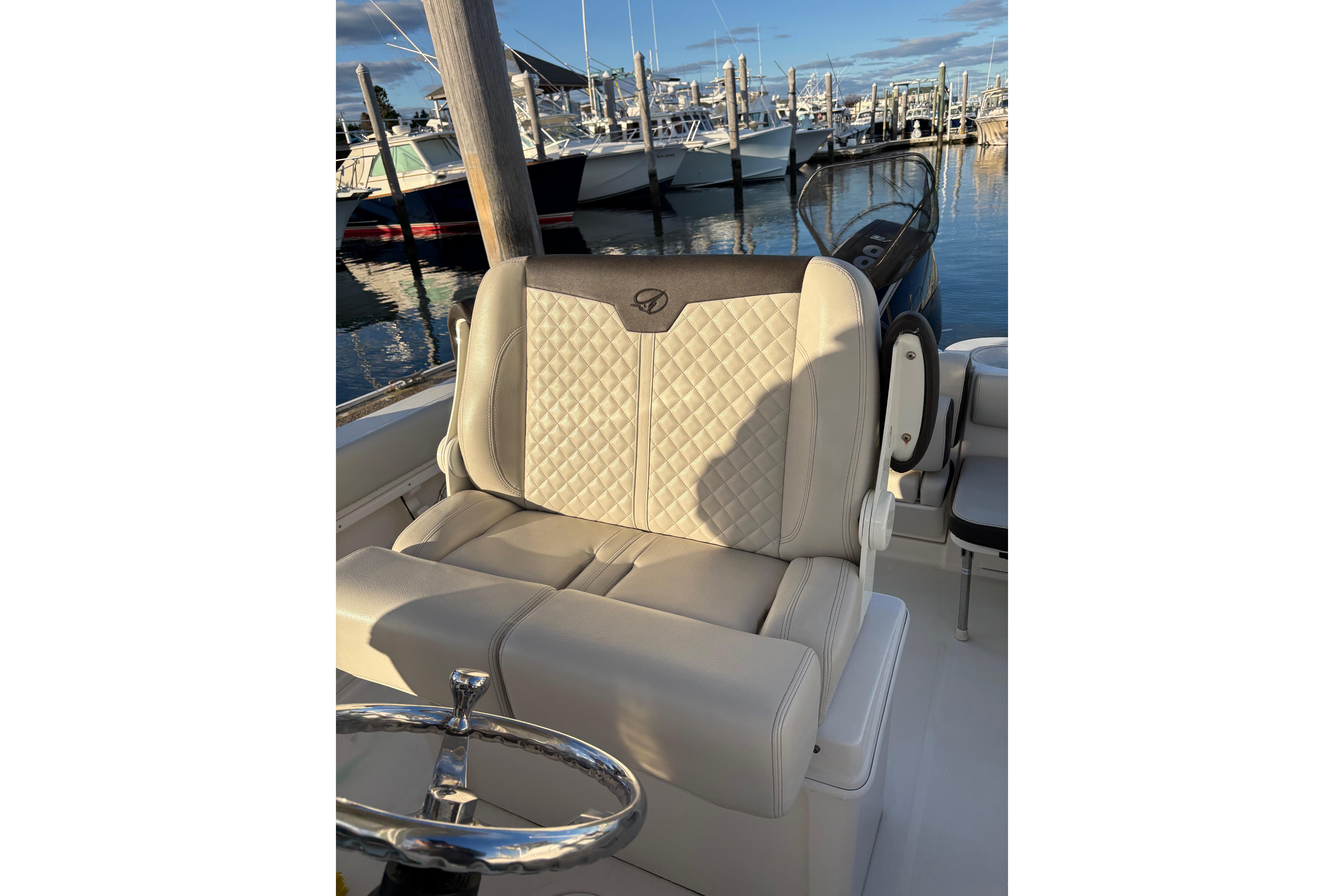 Luxurious seating on 2023 Sailfish 241 CC boat at marina.