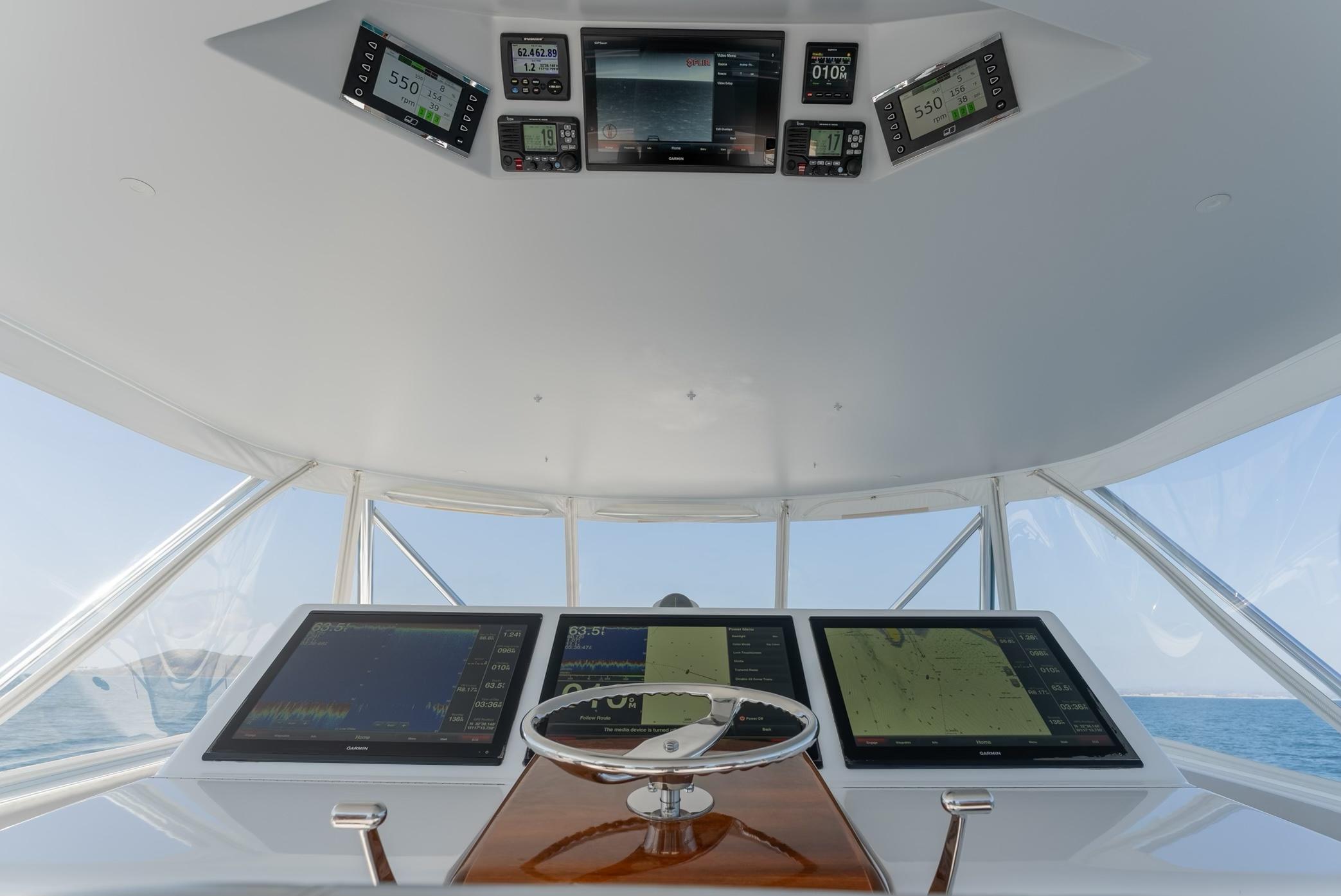 2018 Hatteras GT70 yacht helm with advanced navigation displays and steering wheel.