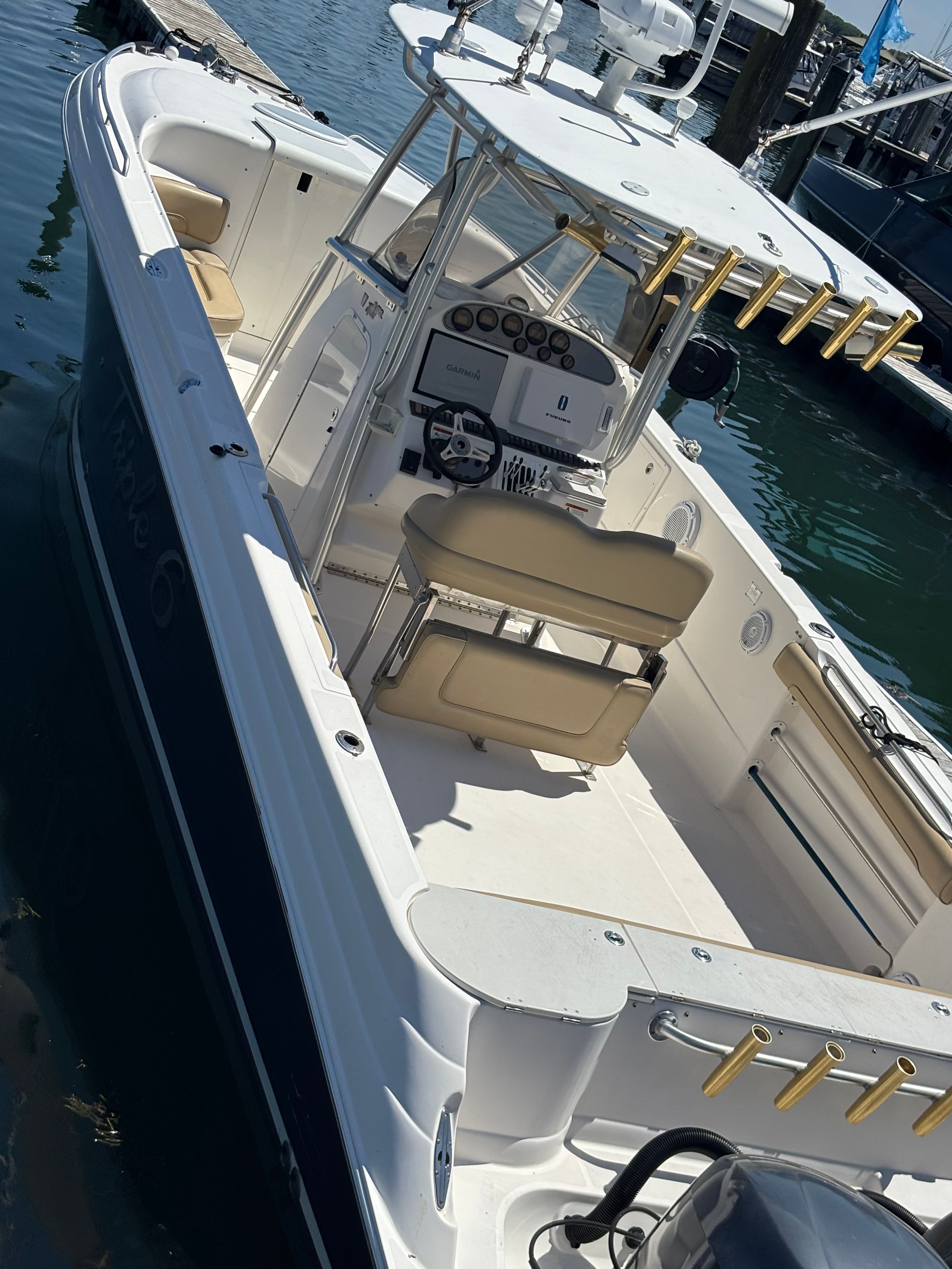 A 2006 Wellcraft Scarab 352 Sport docked. It features an open deck and beige seating.