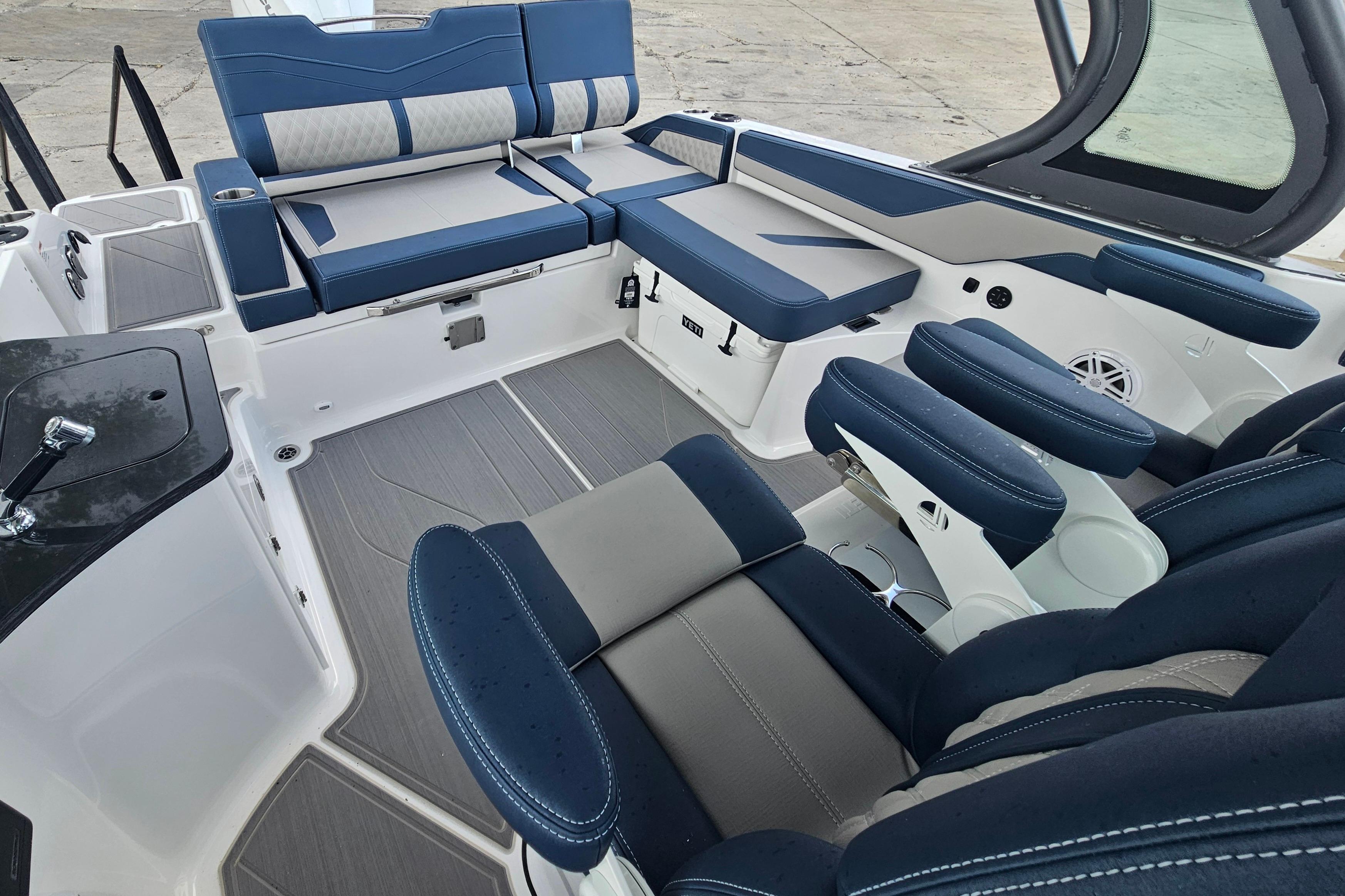 Luxurious interior of 2026 Monterey Elite 27 OB boat with blue and gray seating.