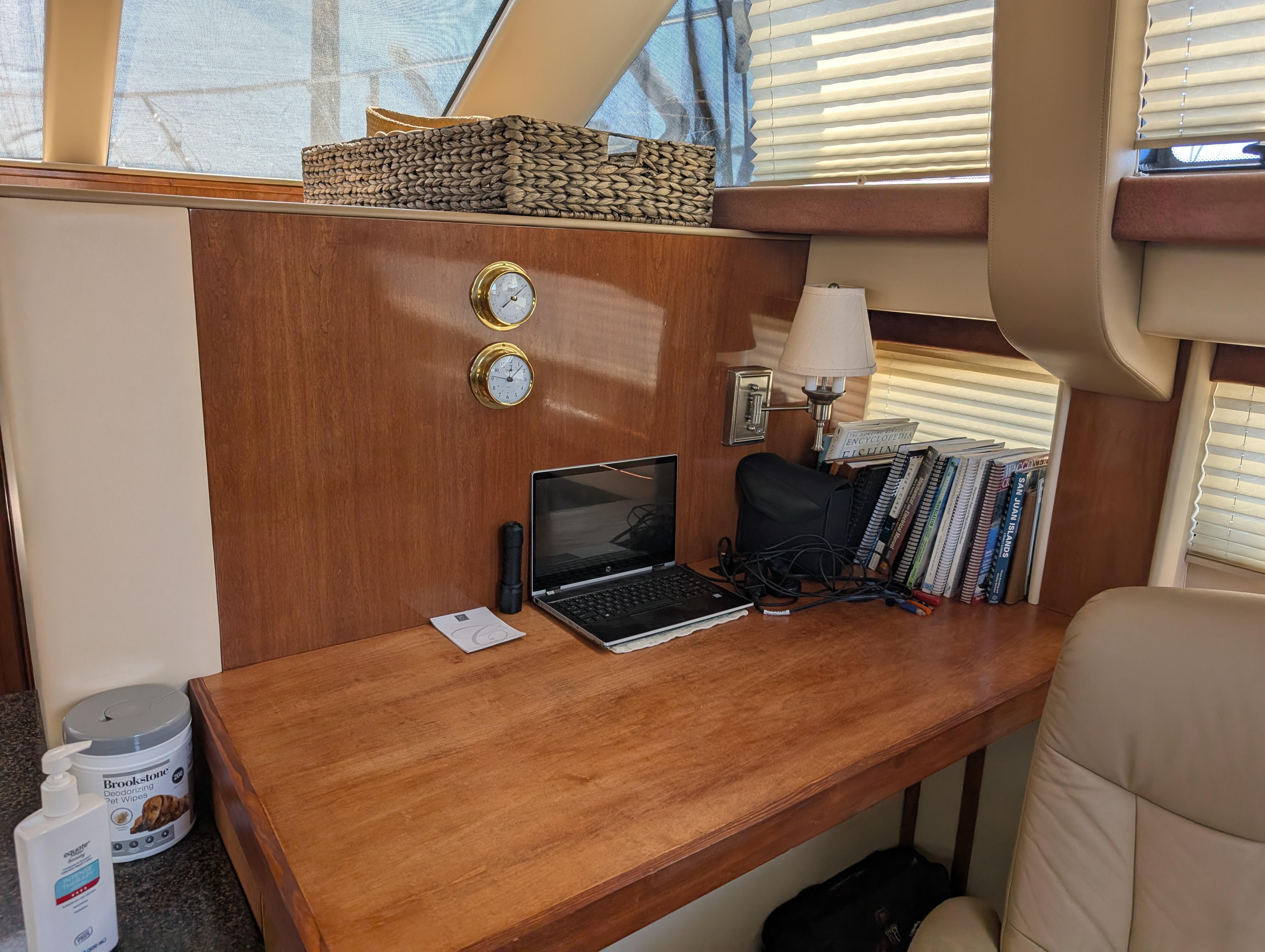Interior of 2006 Meridian 368 yacht with desk, laptop, books, and decor.