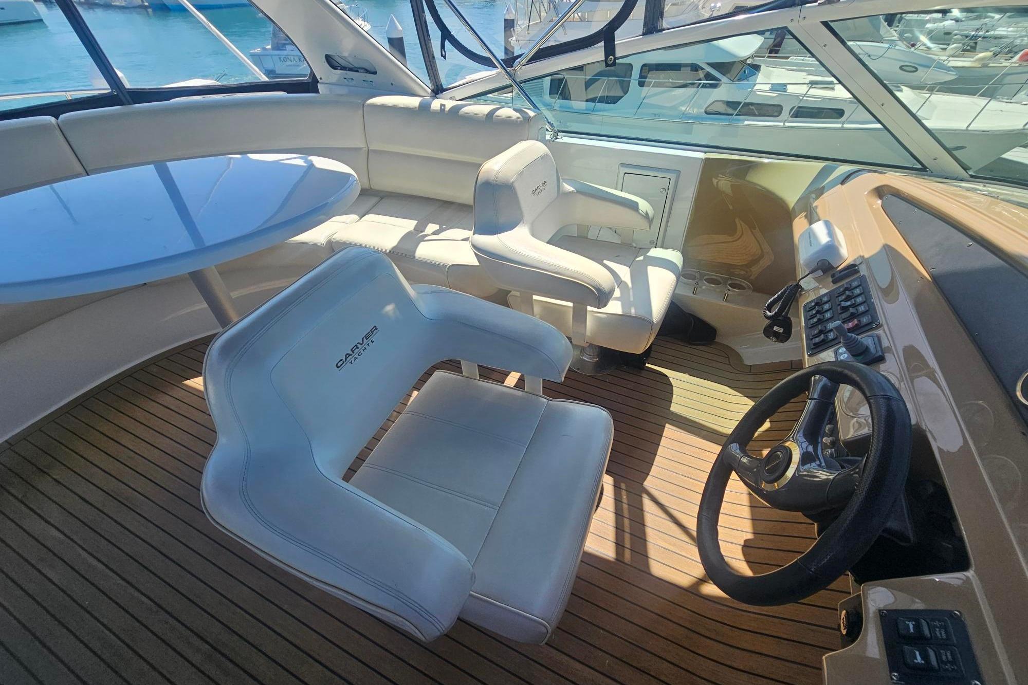 Luxurious 2002 Carver 450 Voyager Pilothouse interior with helm, seating, and table.