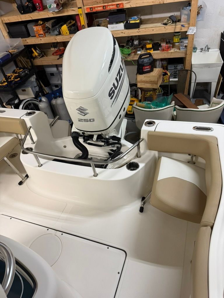 Pioneer 22 SF boat with Suzuki 250 engine in storage room.