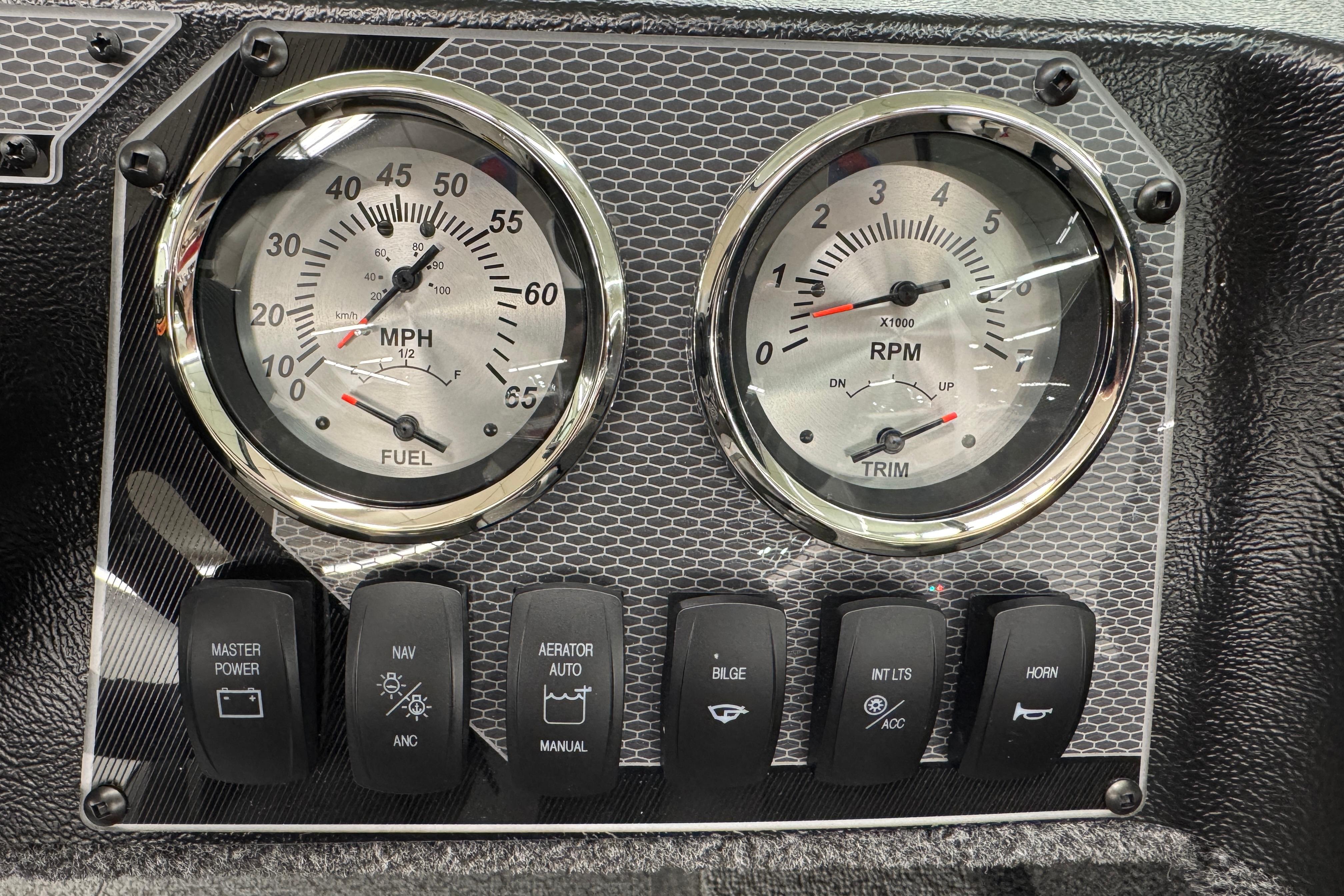 Dashboard of 2026 Lund 1650 Rebel XL Sport with gauges and control switches.