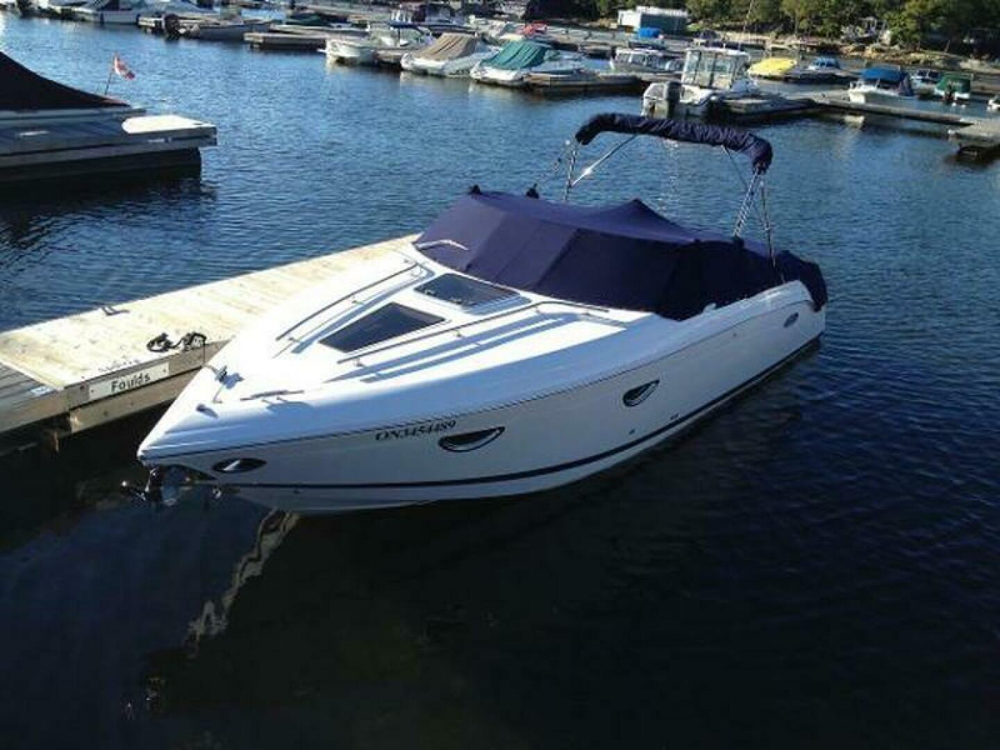 2012 Cobalt 273 boat docked at marina with blue cover.