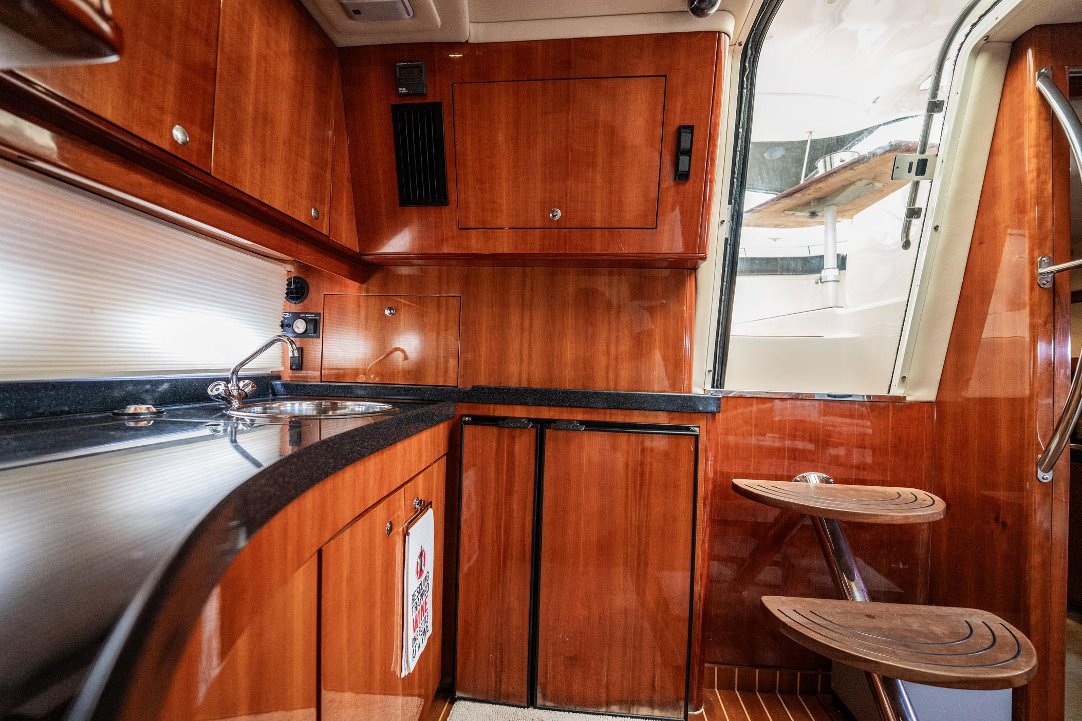 Luxurious 2008 Regal Commodore 4460 yacht interior with sleek wooden cabinetry and modern amenities.