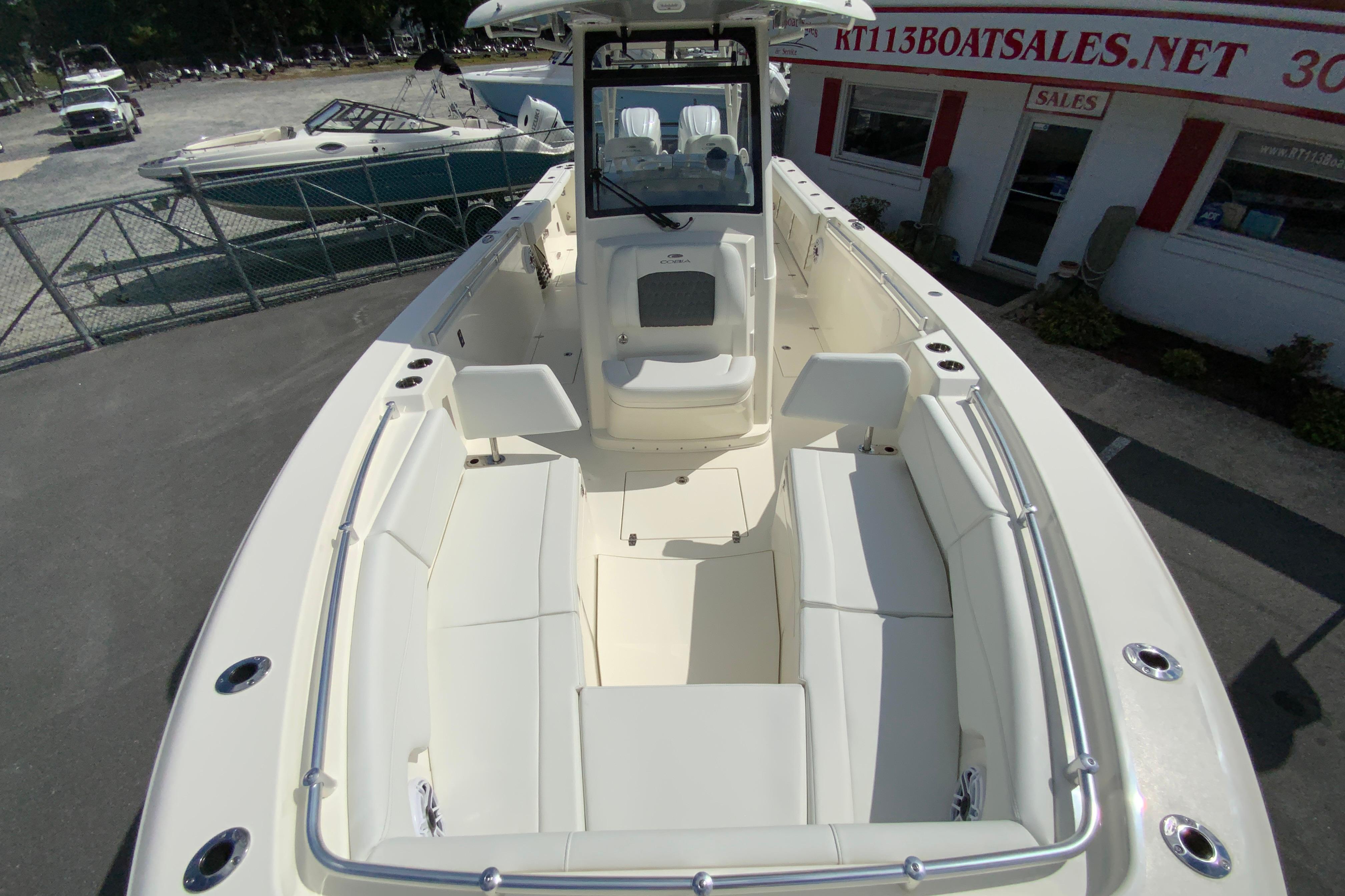 2027 Cobia 320 Center Console boat with spacious seating and modern design at a dealership.