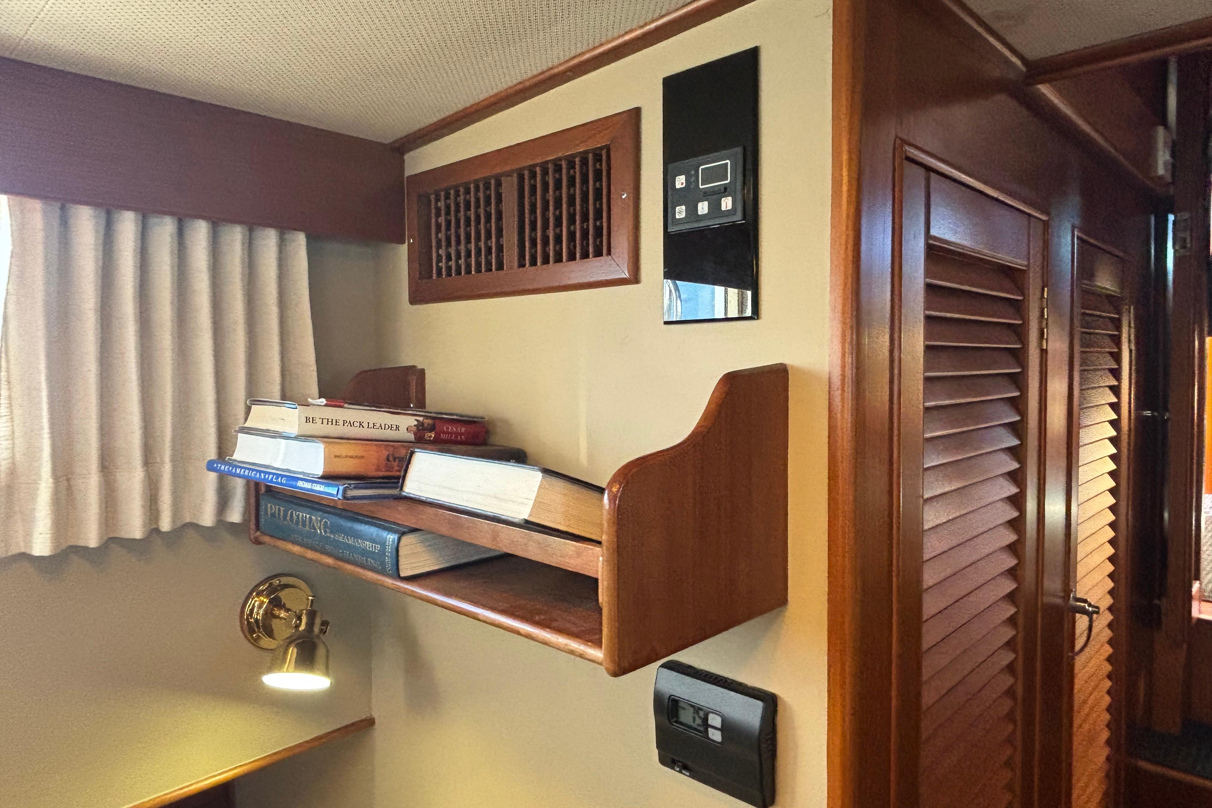1989 Grand Banks 46 Classic interior with bookshelf, wooden paneling, and wall-mounted controls.