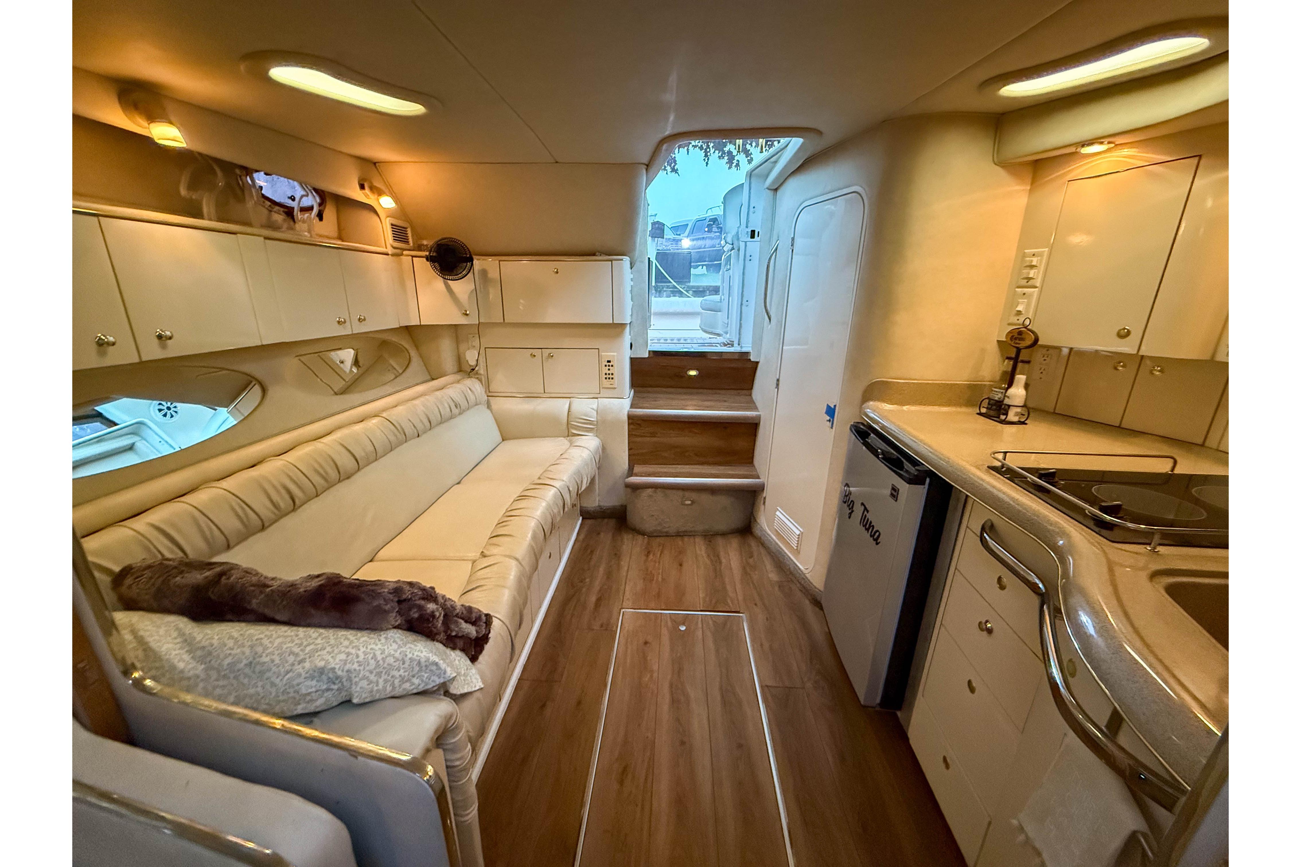 Interior of 1997 Sea Ray 330 Express Cruiser with cozy seating and compact kitchen.