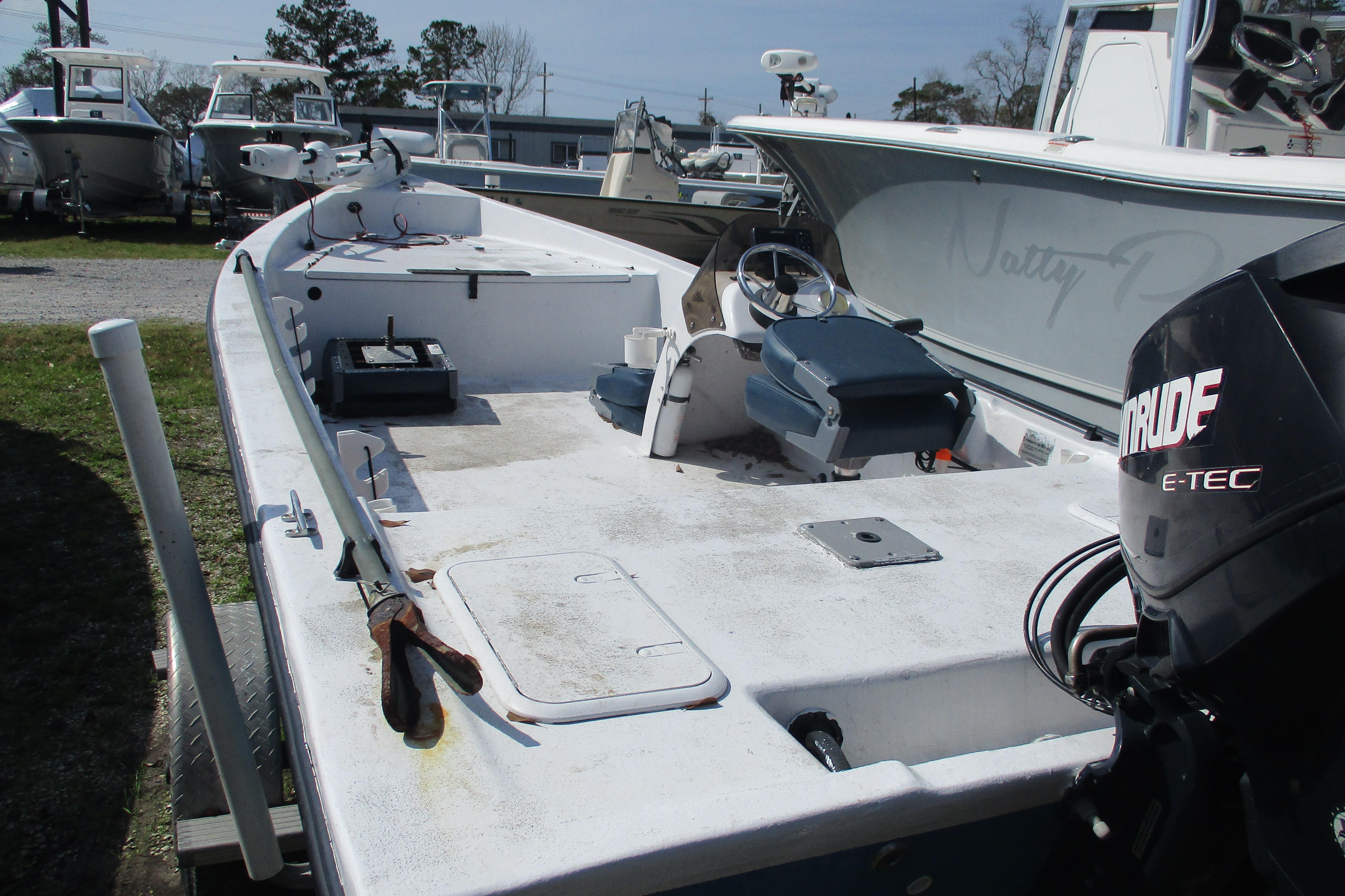 2012 Stumpknocker 17 SPORT boat with Evinrude E-TEC engine, parked among other boats.