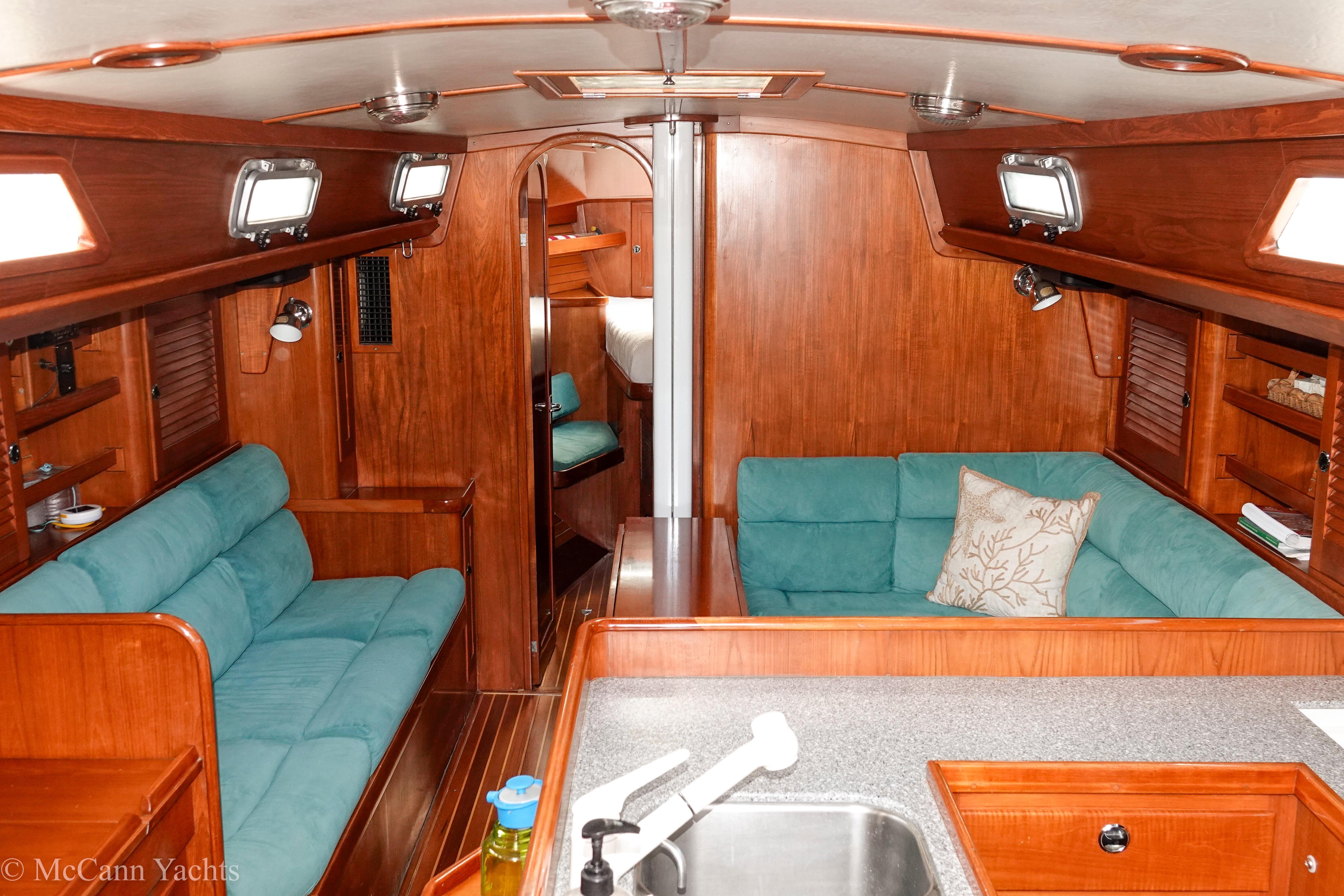 Luxurious 1993 Alden 43 Aft Cockpit yacht interior with teal seating and wooden finishes.