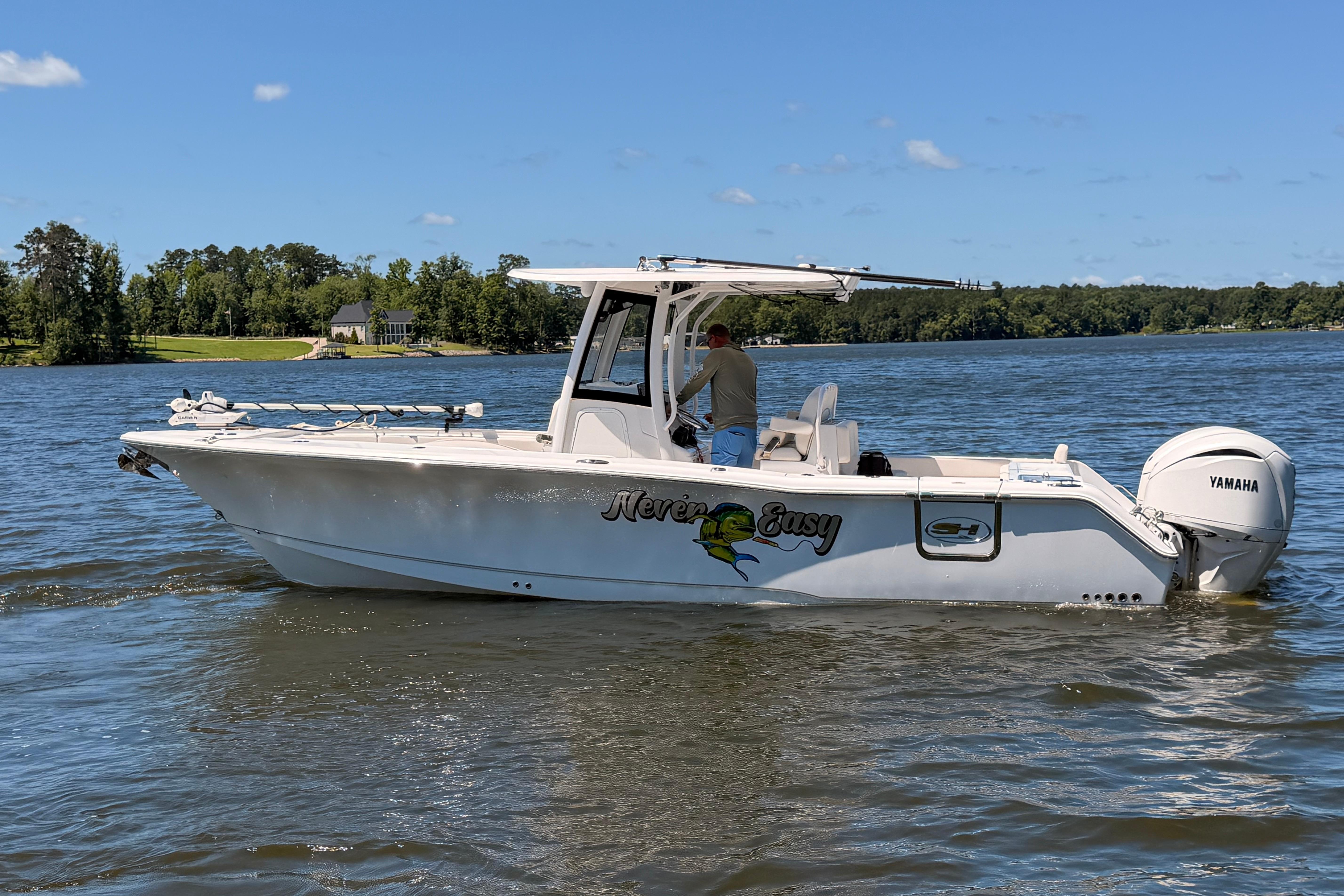 2024 Sea Hunt Gamefish 27 Coffin Box boat on a serene lake.