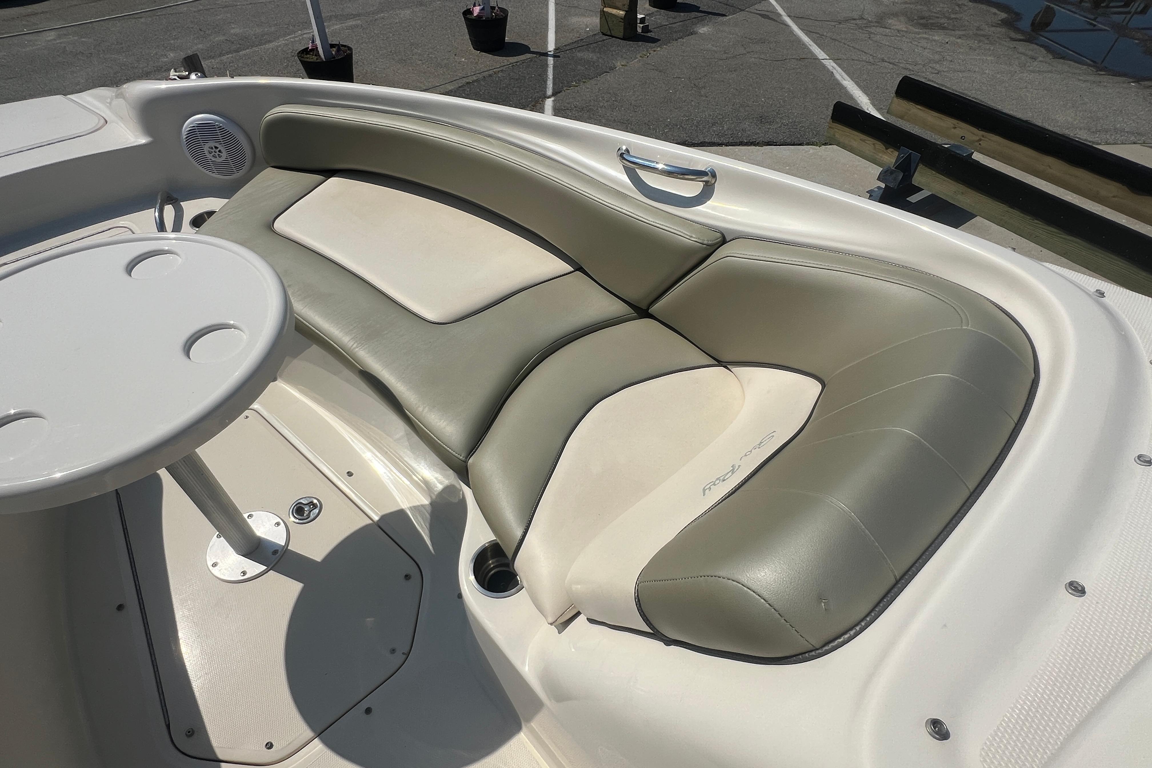 2005 Sea Ray 240 Sundeck boat interior with cushioned seating and table.