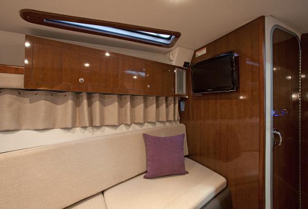 Manufacturer Provided Image: Interior cabin of 2017 Four Winns Vista 275 with wooden cabinets and a TV.