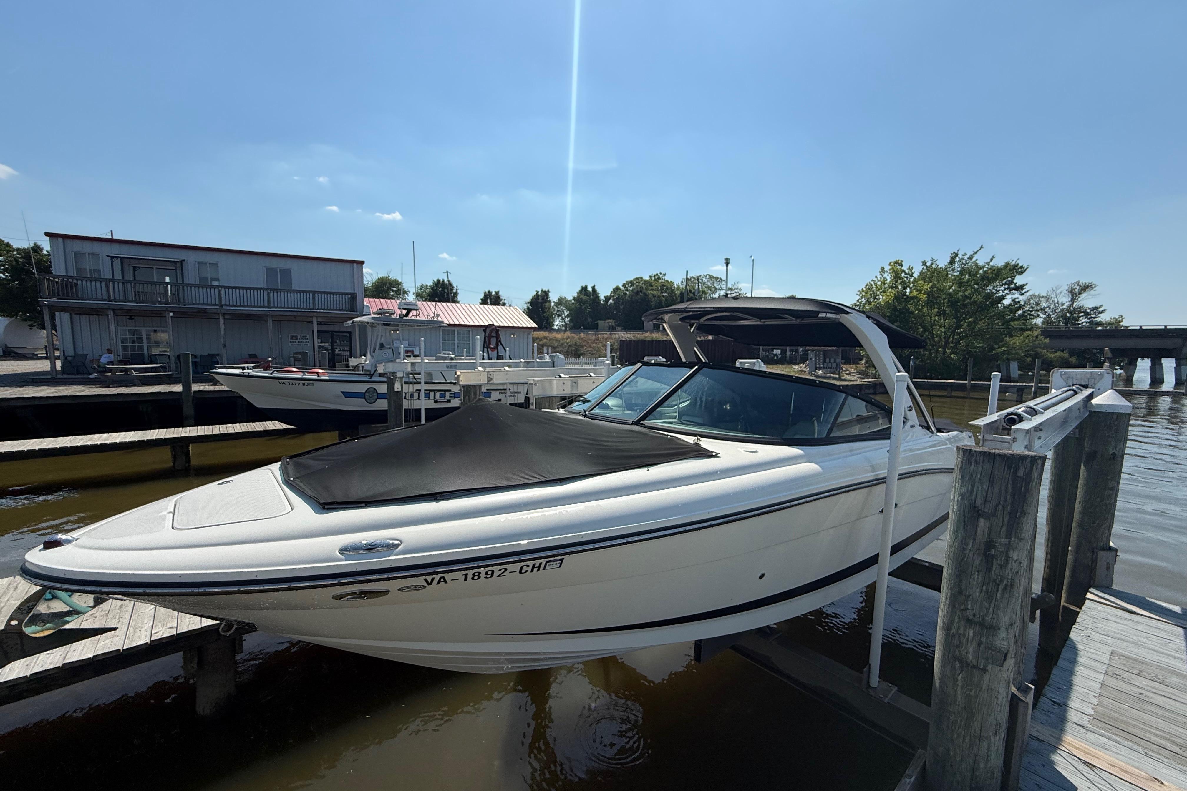 2011 Sea Ray 270 SLX boat docked at a marina under clear skies.