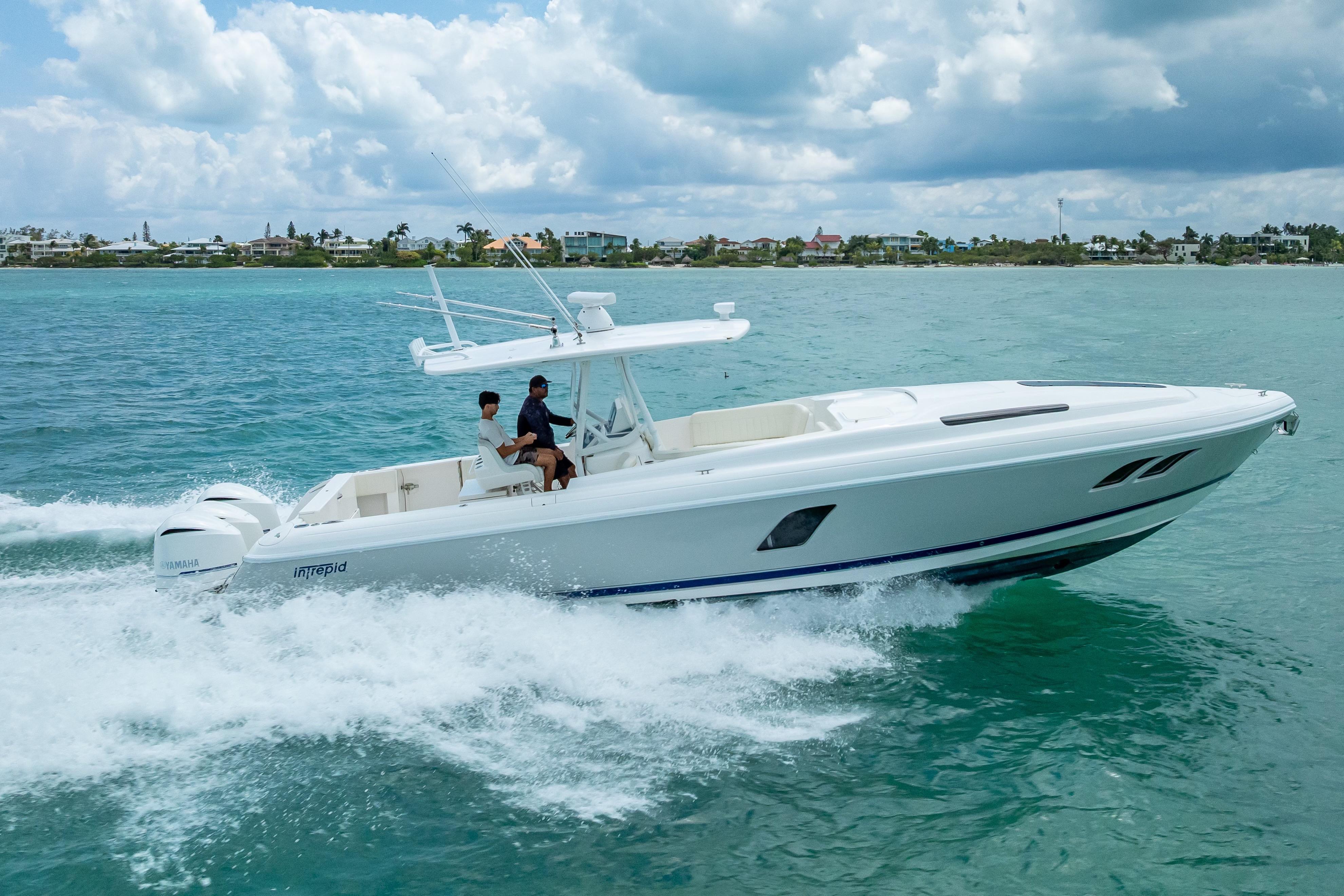 2015 Intrepid 400 Cuddy cruising on turquoise ocean waters under a cloudy sky.