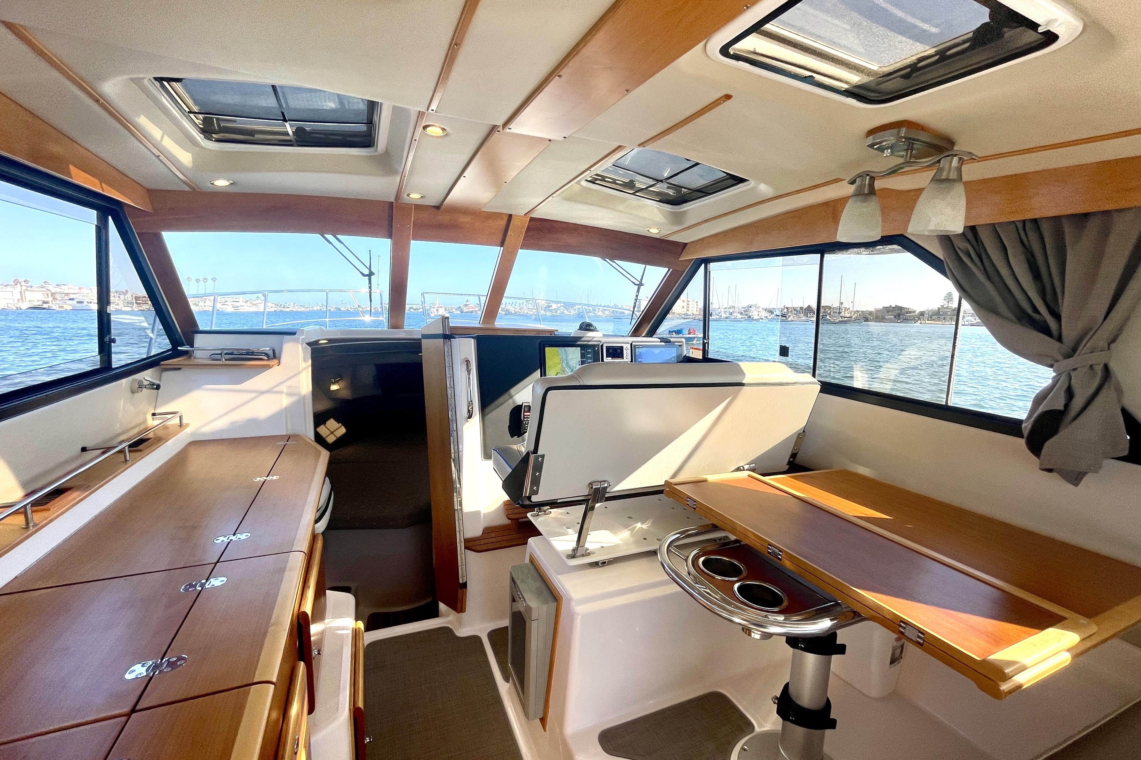 Interior of 2019 Cutwater C-302 Coupe boat with wood accents and water view.