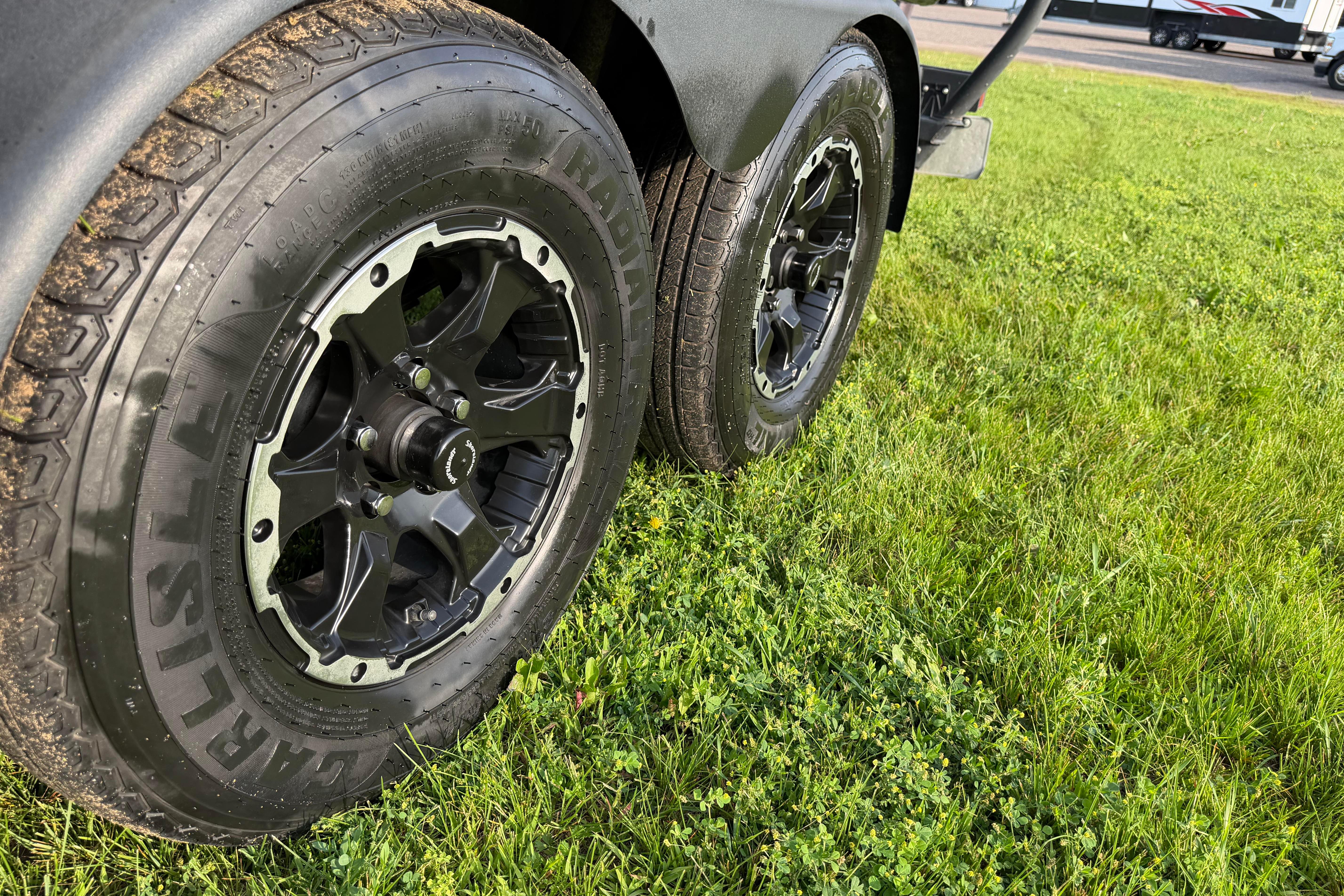 2019 Alumacraft Trophy 205 trailer wheels on grass, showcasing rugged tire design.