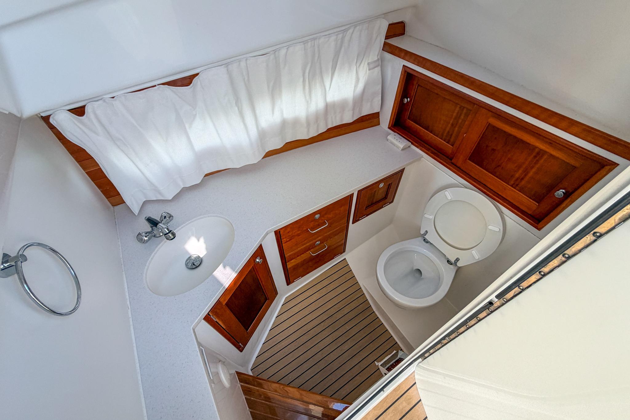 Luxurious 2022 MJM 3 yacht bathroom with wooden cabinetry and modern fixtures.