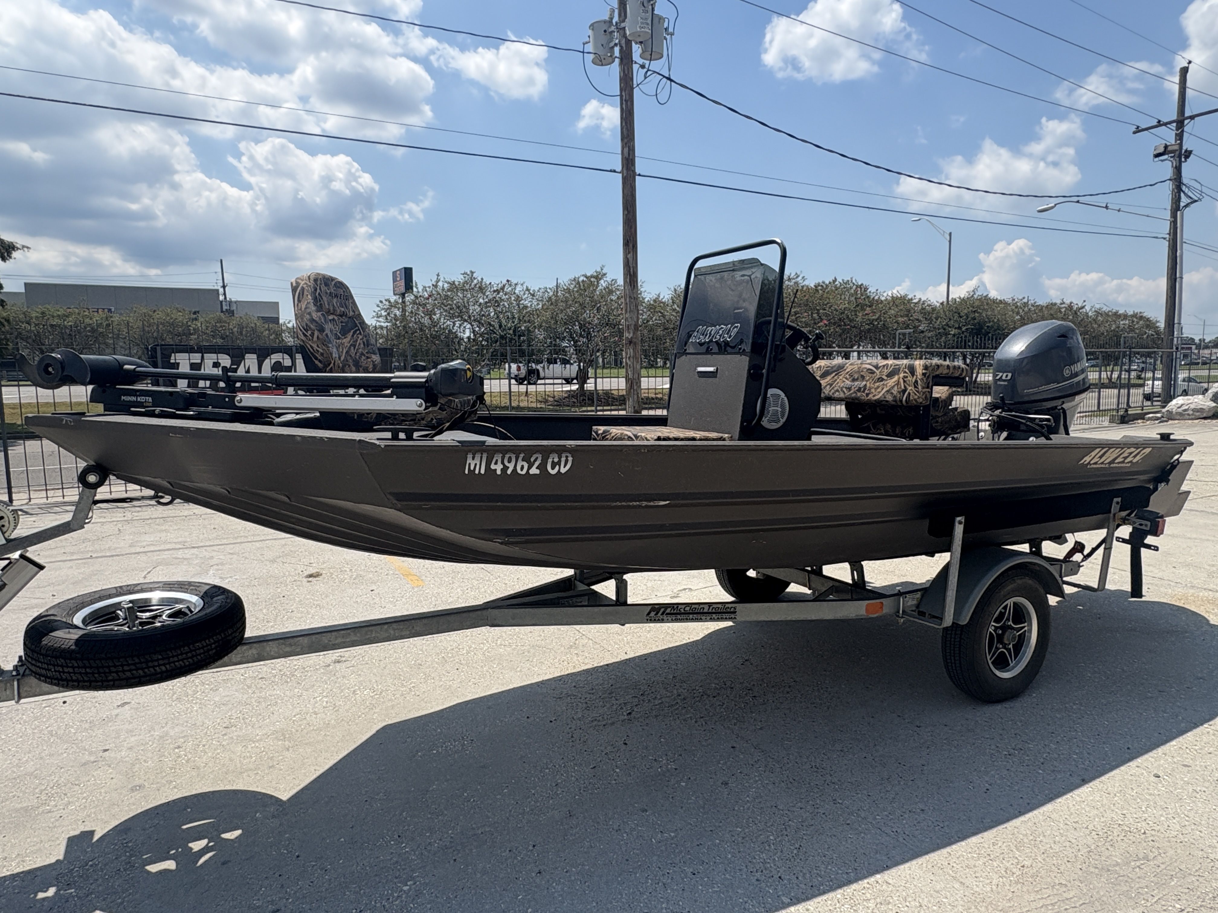 2023 Alweld 16x52 Marsh boat on trailer, parked outdoors under a cloudy sky.
