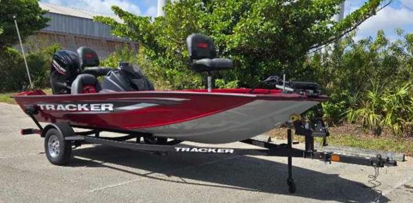 2025 Tracker Pro Team 175 boat on trailer, red and silver design, parked outdoors.