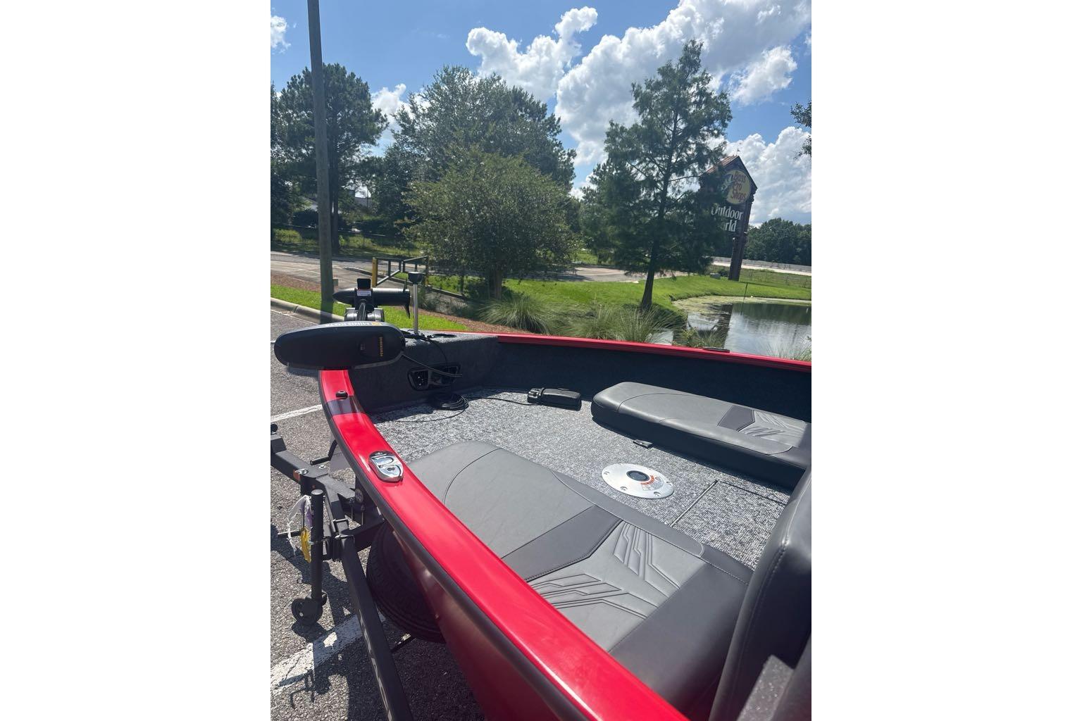 2026 Tracker Pro Guide V-175 Combo boat, red exterior, parked near a pond under a sunny sky.
