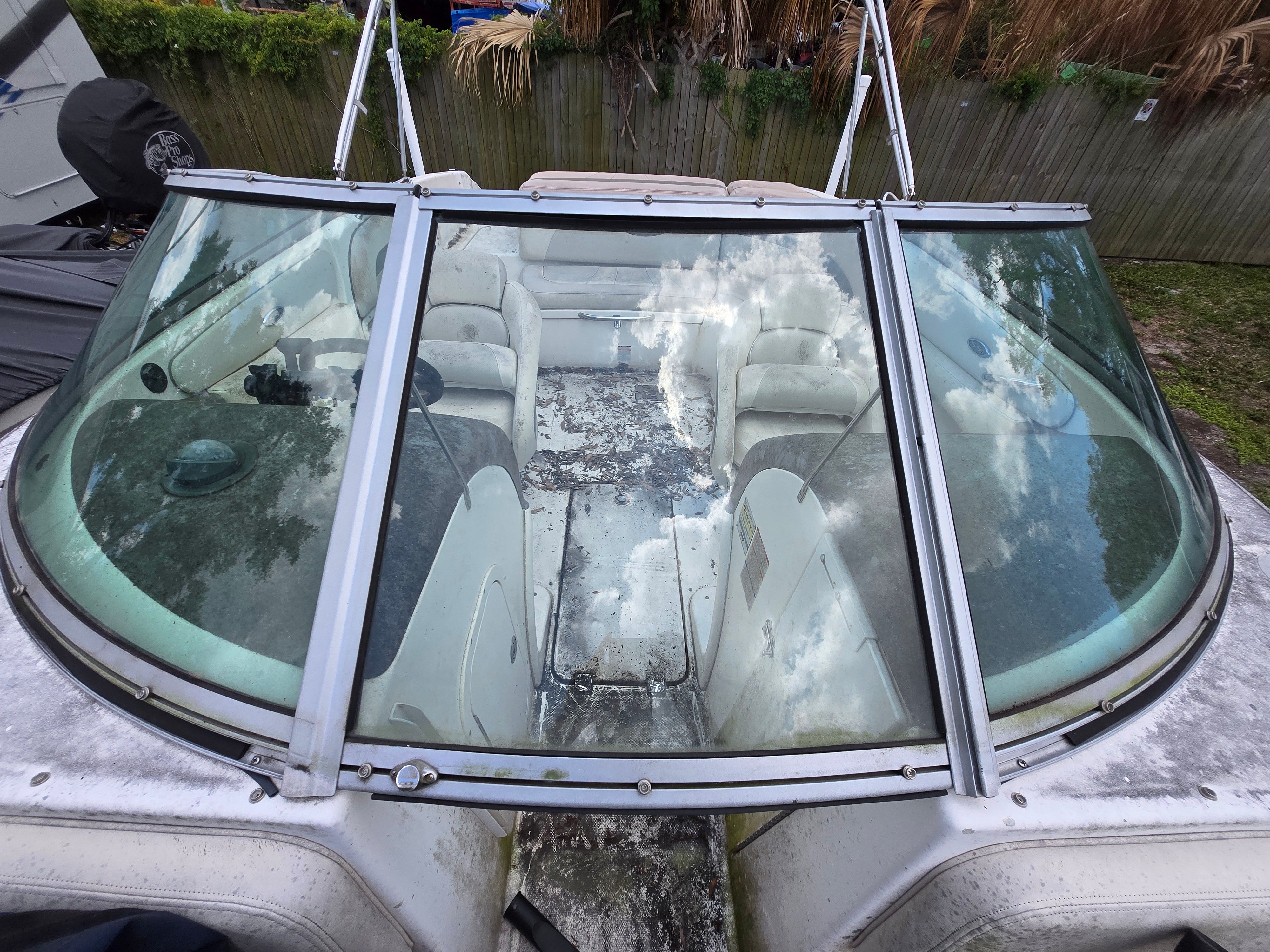 The image shows the cockpit of a 2006 Chaparral 220 SSi boat with worn seats.
