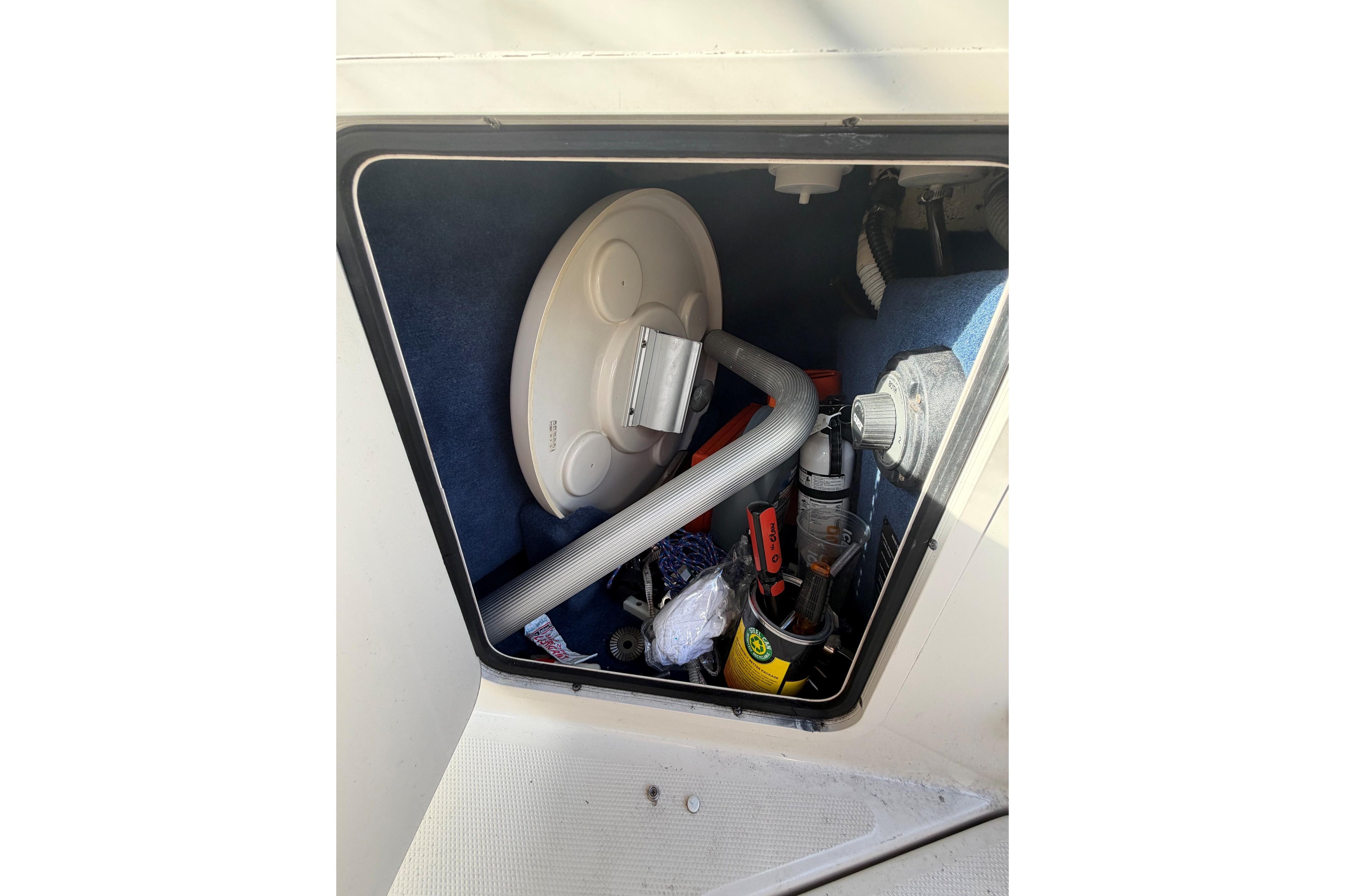 Storage compartment of a 2000 Sea Ray 240 Sundancer boat with various equipment.