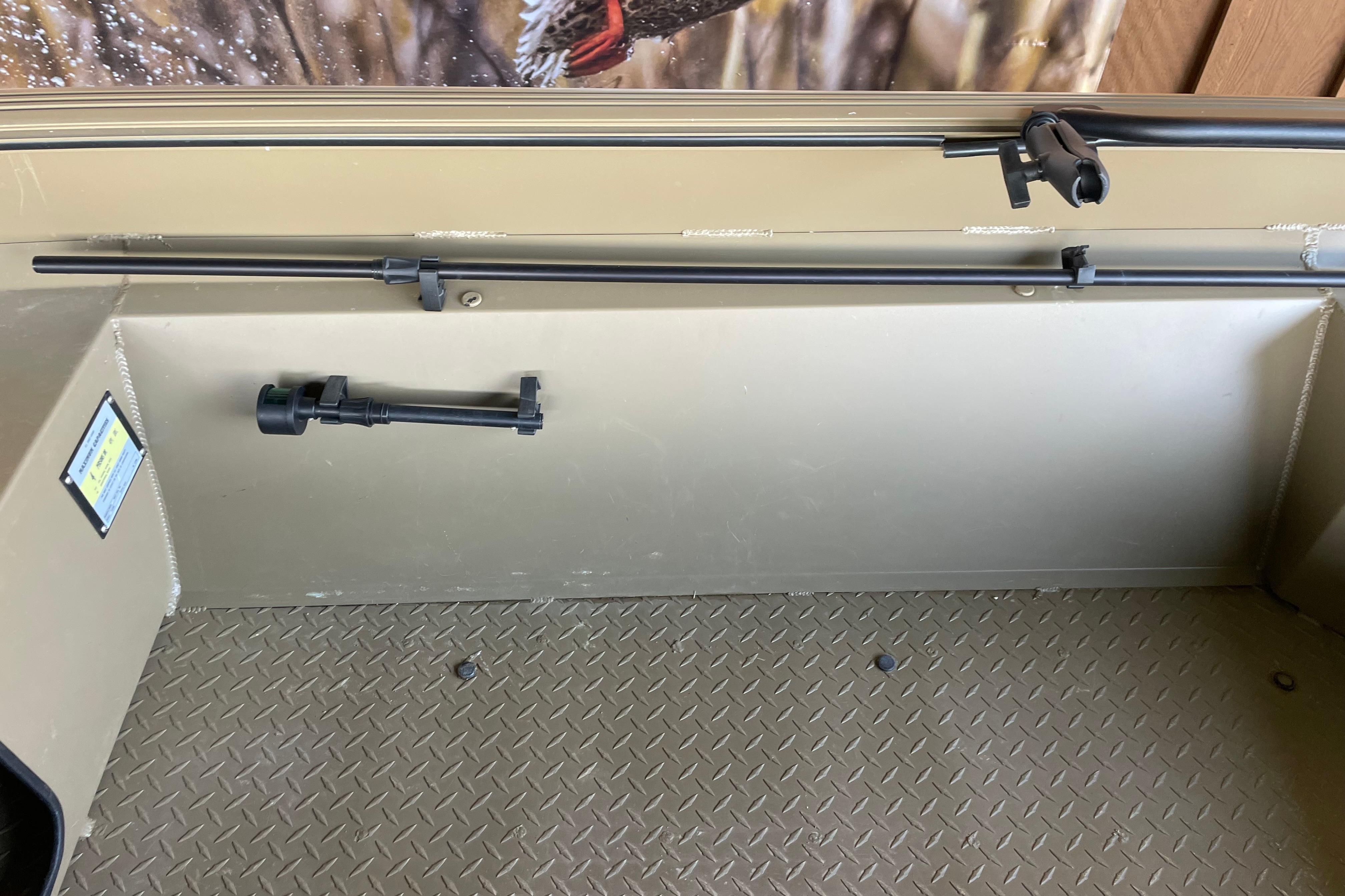 Interior of 2025 Edge Duck Boats 550, featuring rod holders and diamond-patterned flooring.
