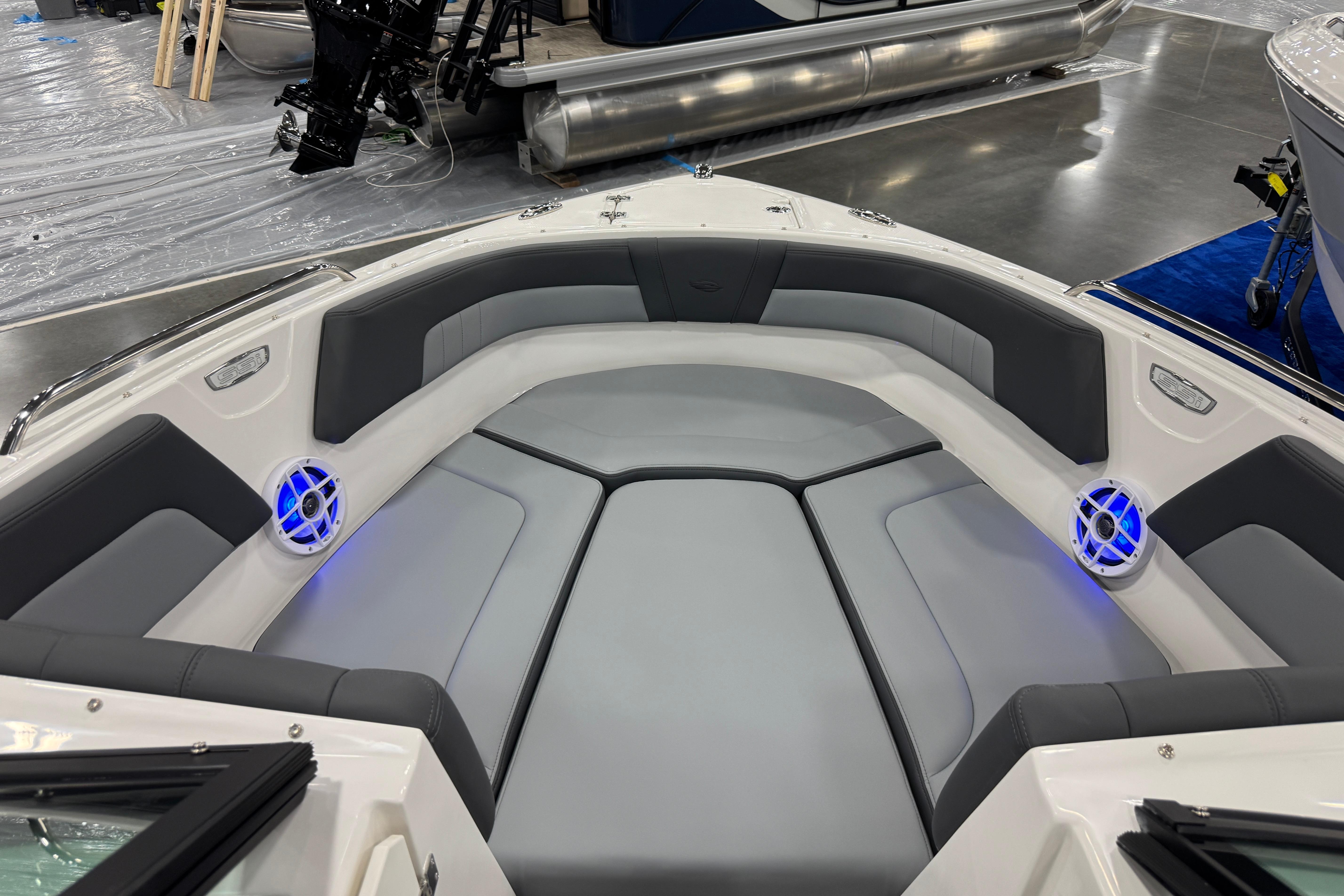 2026 Chaparral 23 SSi boat interior with gray seating and blue-lit speakers.