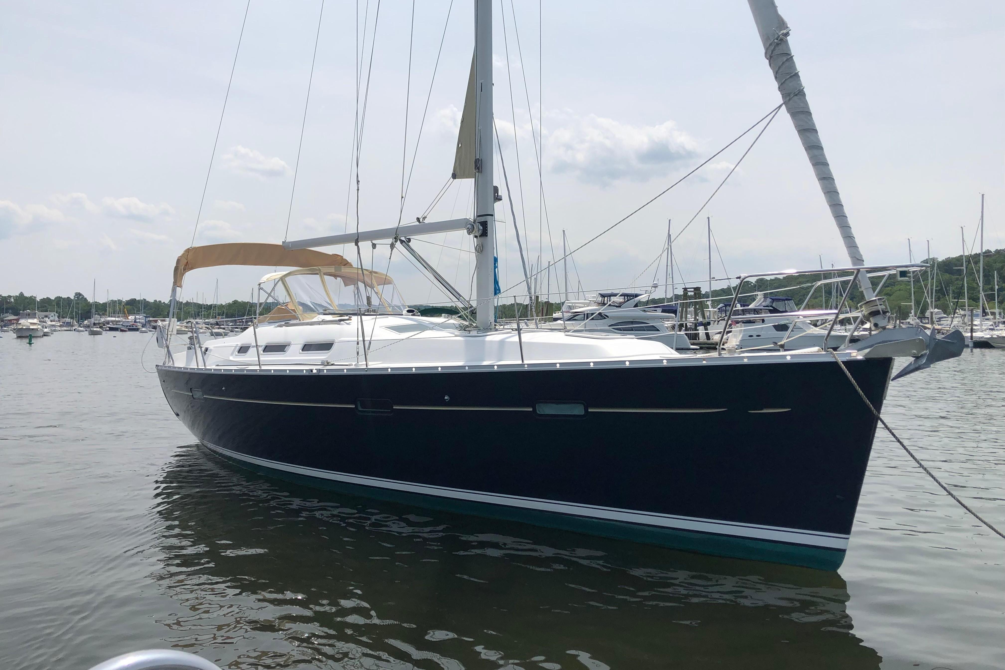 2006 Beneteau 373 sailboat docked in a marina, calm waters, overcast sky.