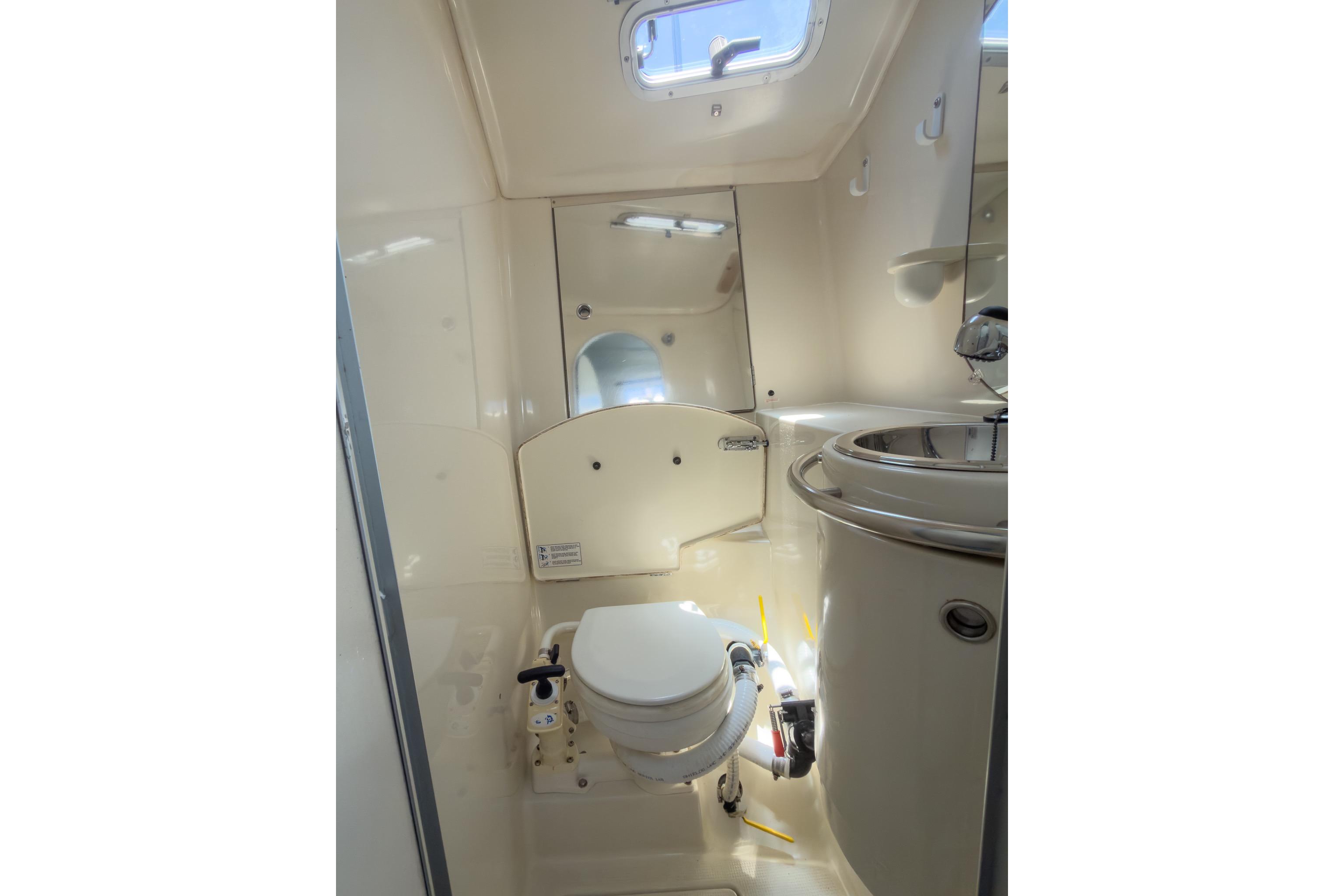 Bathroom interior of 1993 Beneteau First 38 s5 yacht, featuring toilet and sink.