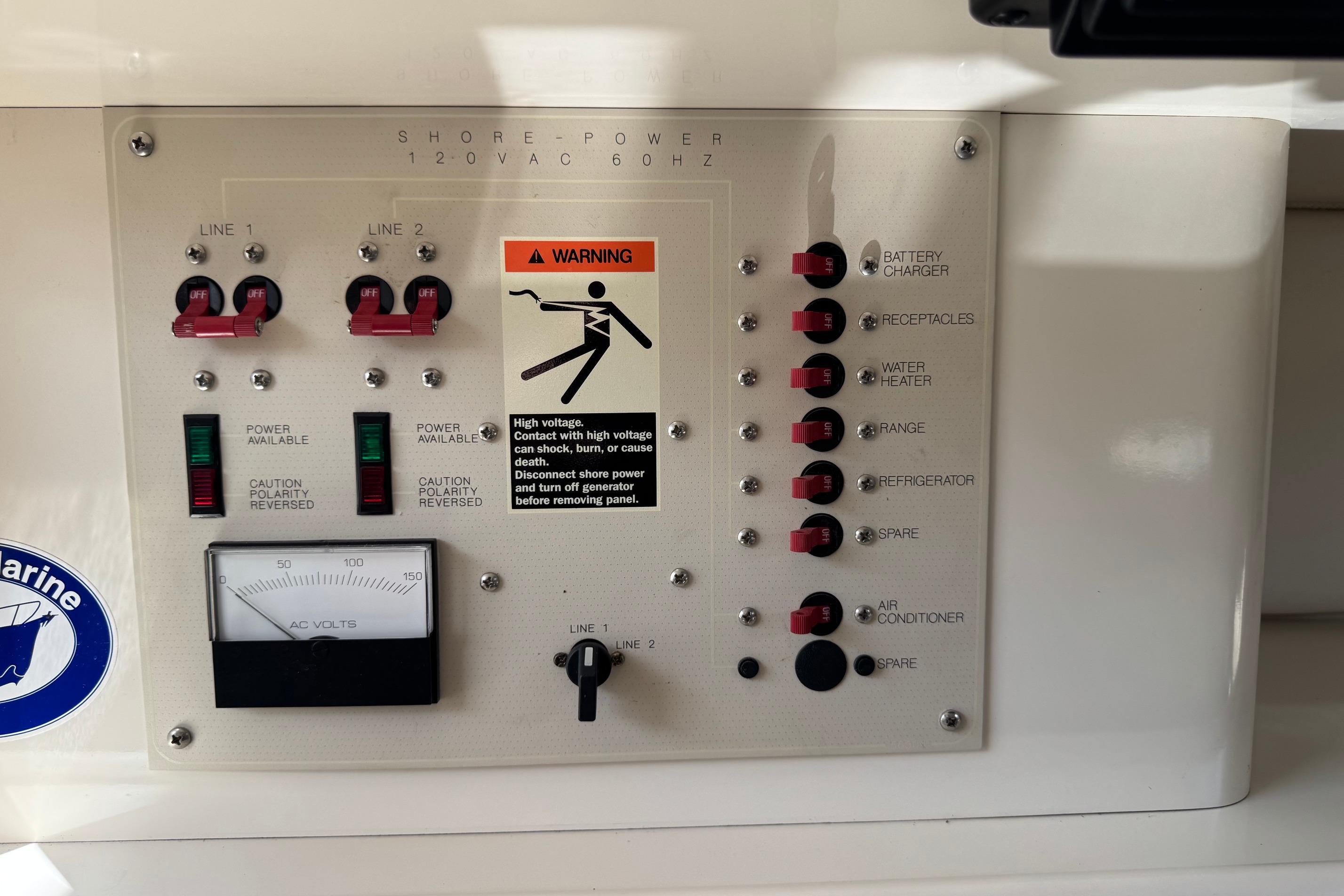 Electrical control panel on a 2000 Maxum 2400 SCR boat, featuring switches and warning label.