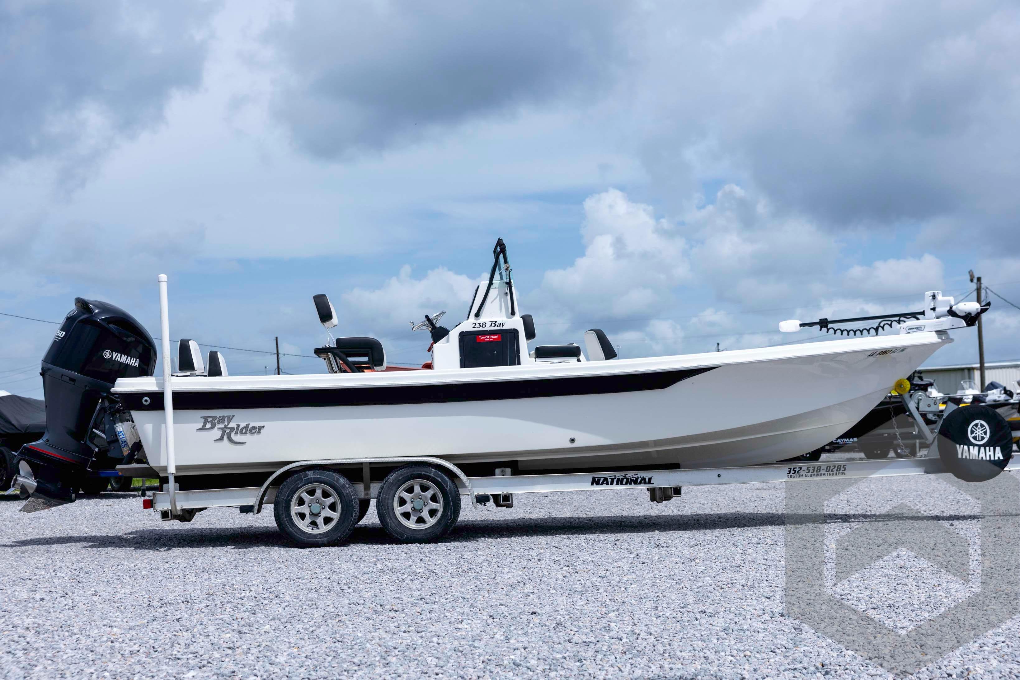 2018 Bay Rider 238 Bay boat on trailer, featuring Yamaha outboard motor, under cloudy sky.