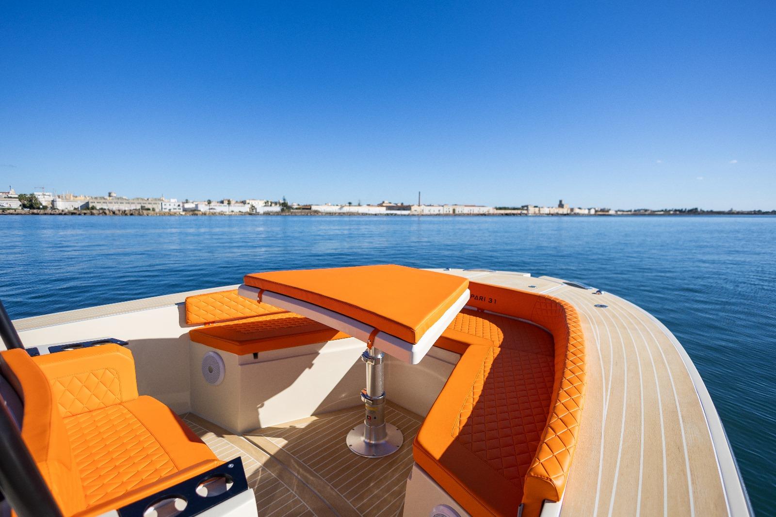 Luxury AlCustom LIPARI 31 boat with orange seating, cruising on calm waters, 2025 model.