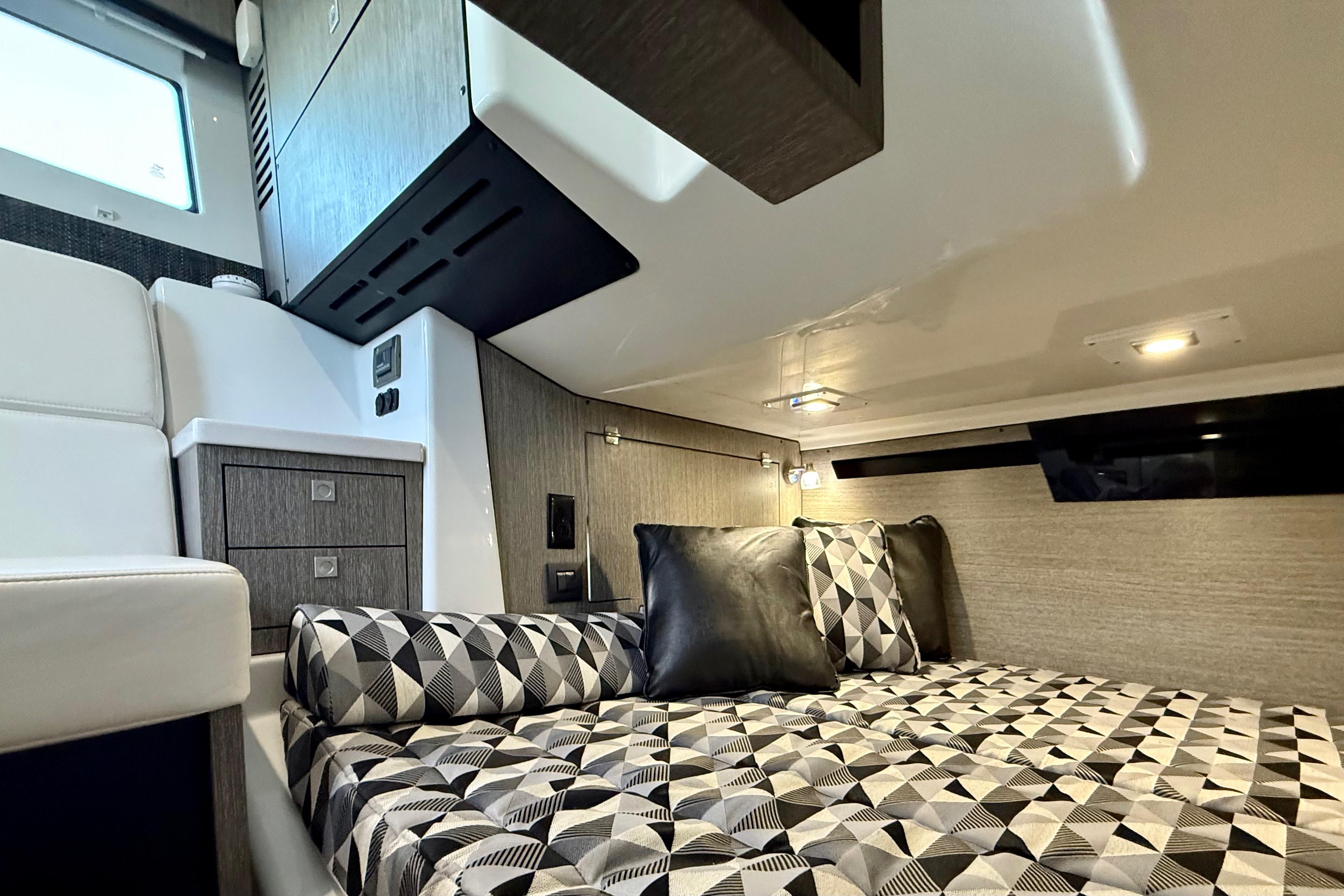 Luxurious interior cabin of 2022 Monterey 385SS Super Sport boat with geometric bedding.
