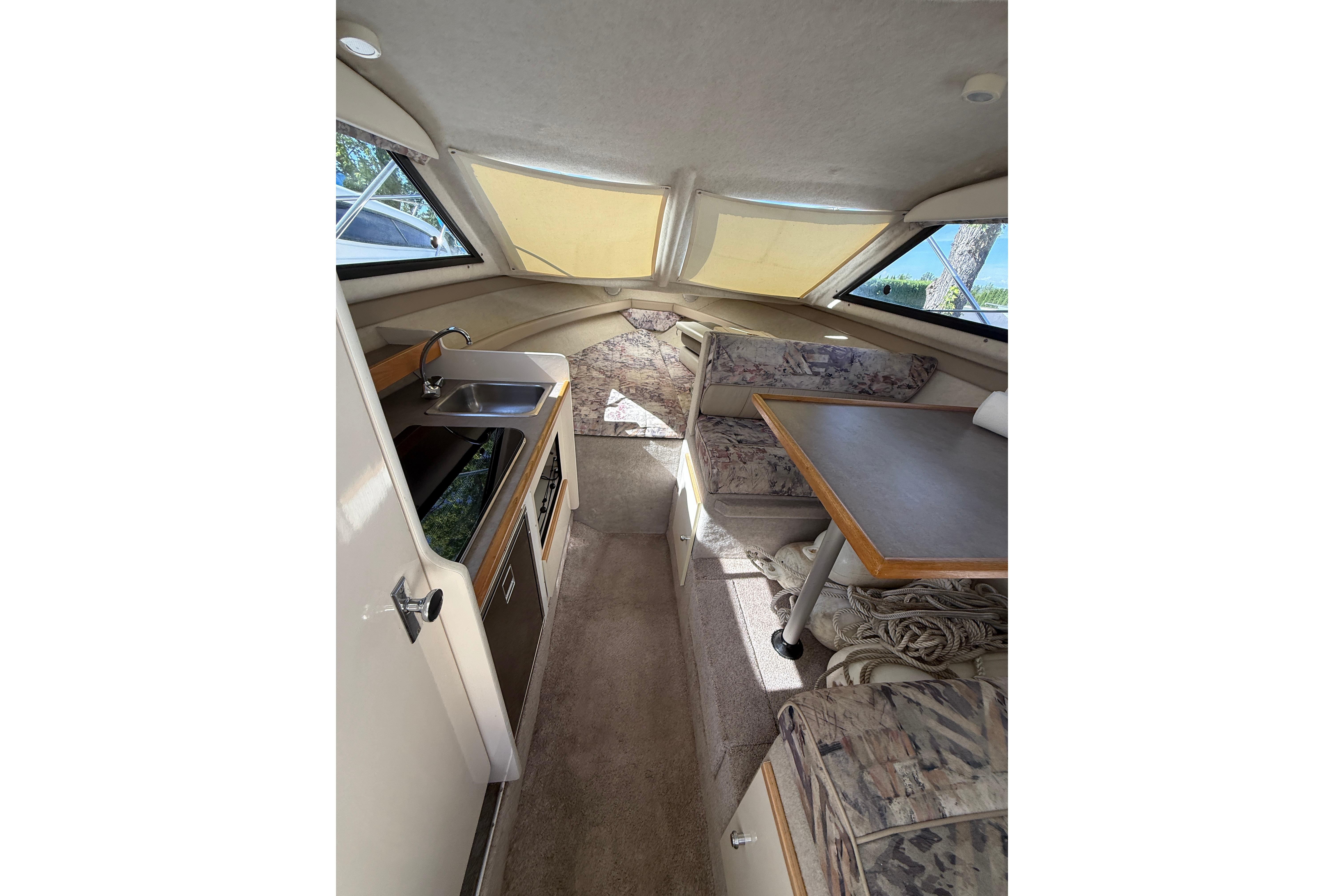 Interior of 1997 Bayliner 2452 Ciera Express with kitchenette and seating area.