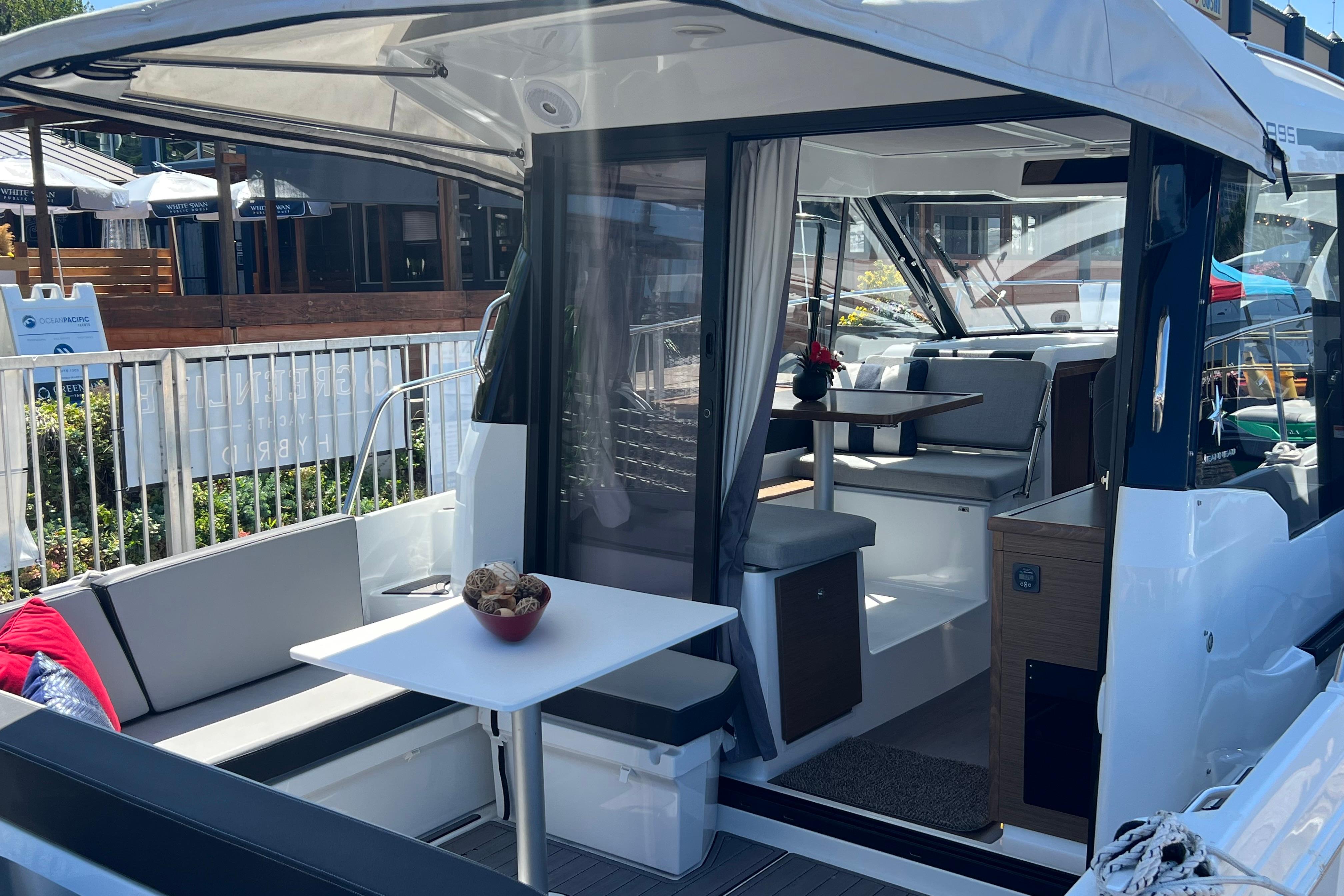 2018 Jeanneau NC 895 boat interior with seating and table, docked at marina.