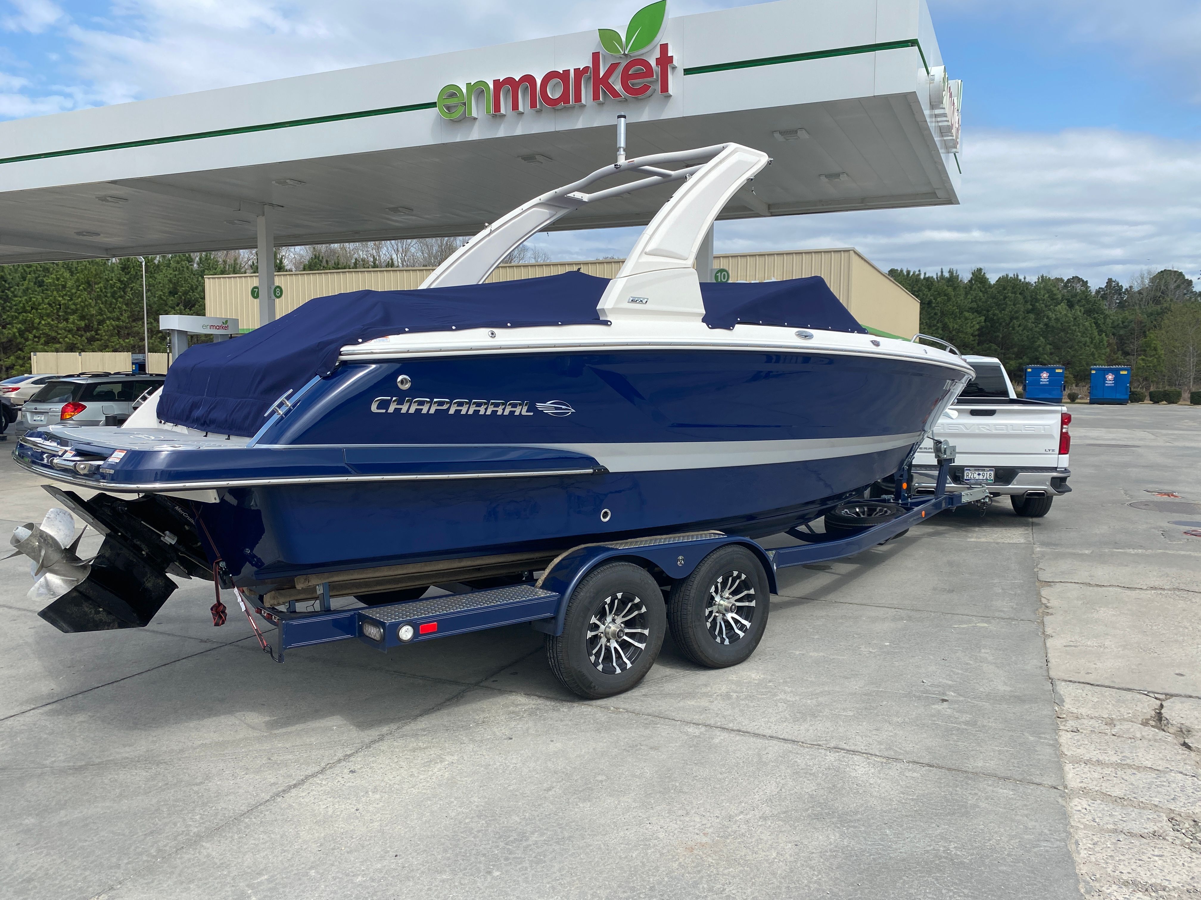 2020 Chaparral 256 SSX boat on trailer at gas station.