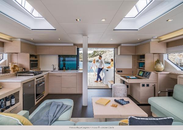 Luxurious interior of 2025 Lagoon 55 yacht with modern kitchen and lounge area.