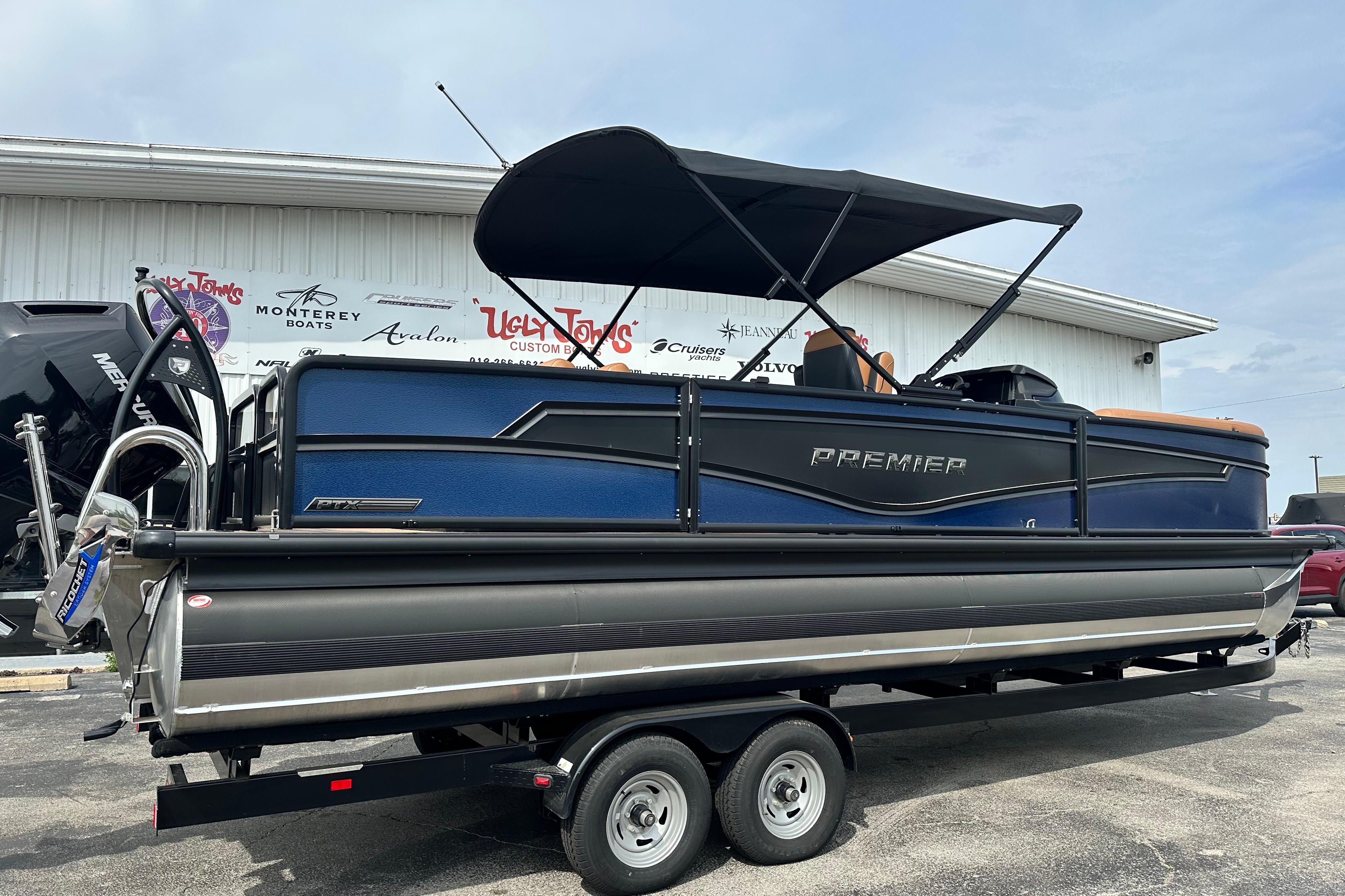 2026 Premier 250 Intrigue RLO pontoon boat on trailer, blue and black design.