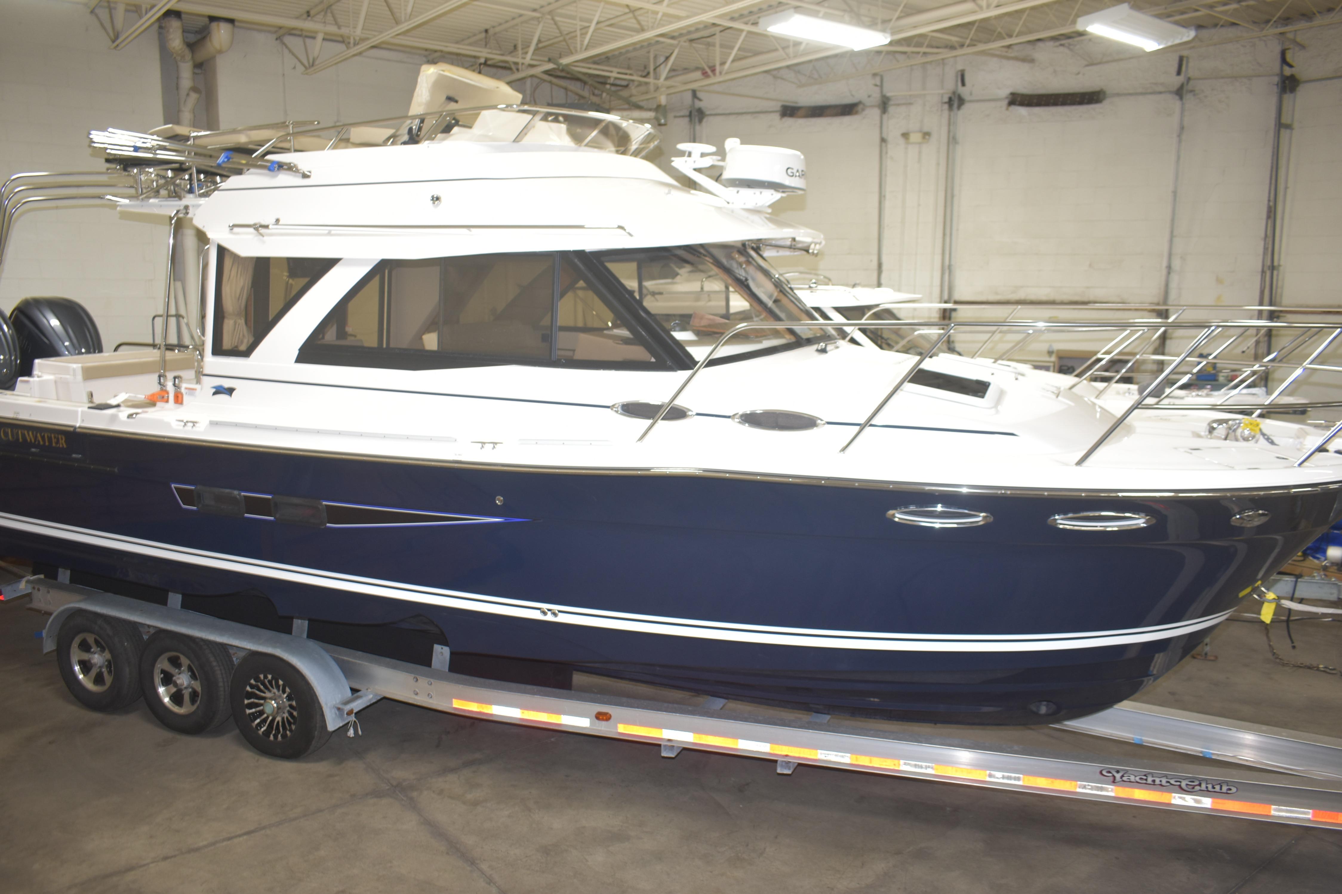 2026 Cutwater C-32 CB boat on trailer in indoor storage facility.