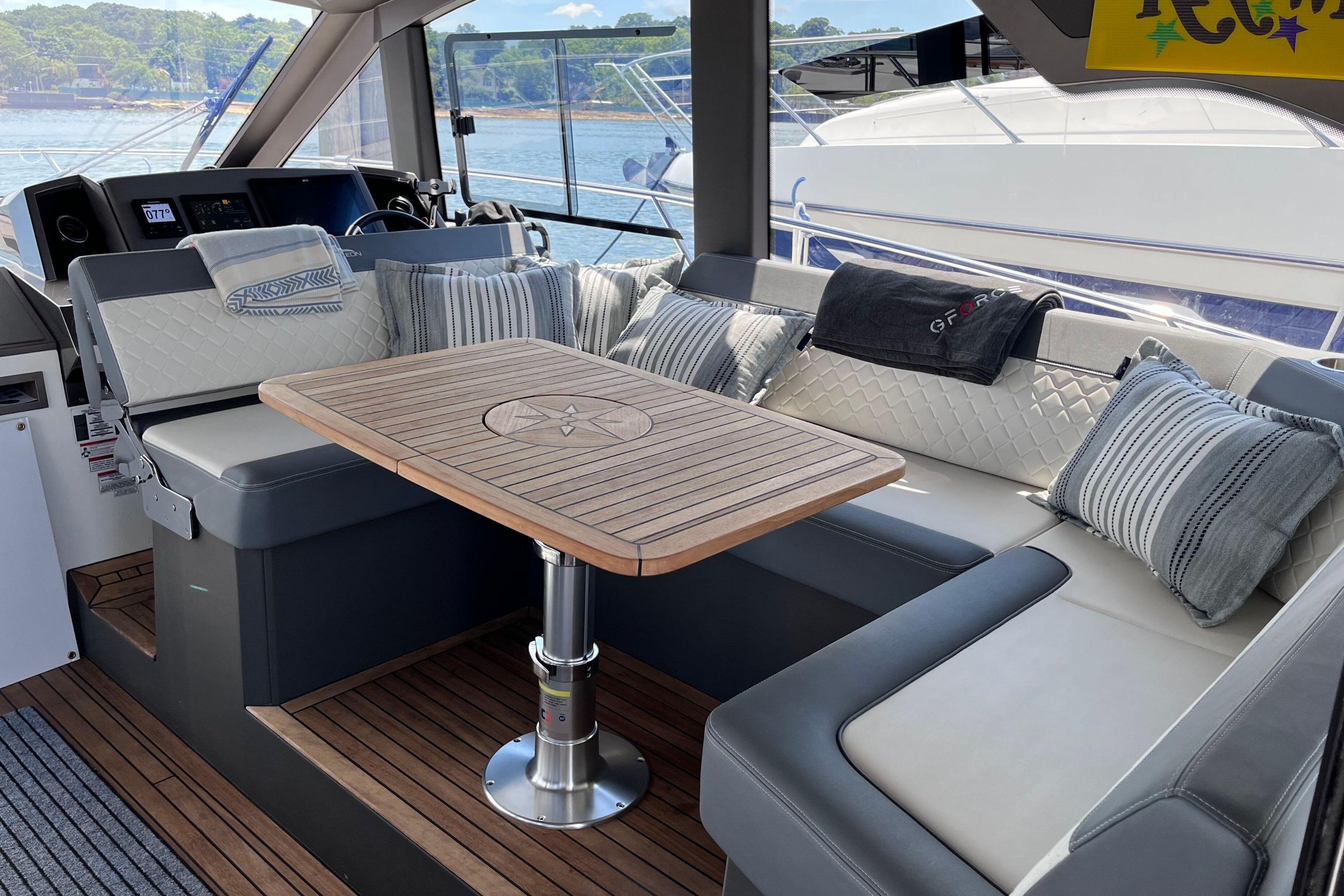 Luxurious seating area on 2024 Galeon 425 HTS yacht with elegant cushions and wooden table.