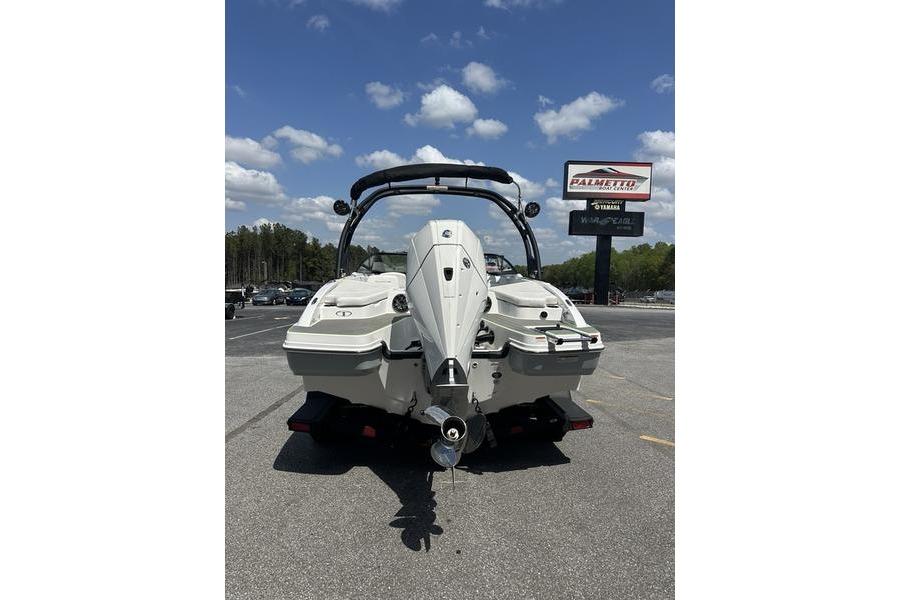2024 Tahoe 210 S boat rear view in parking lot under blue sky.