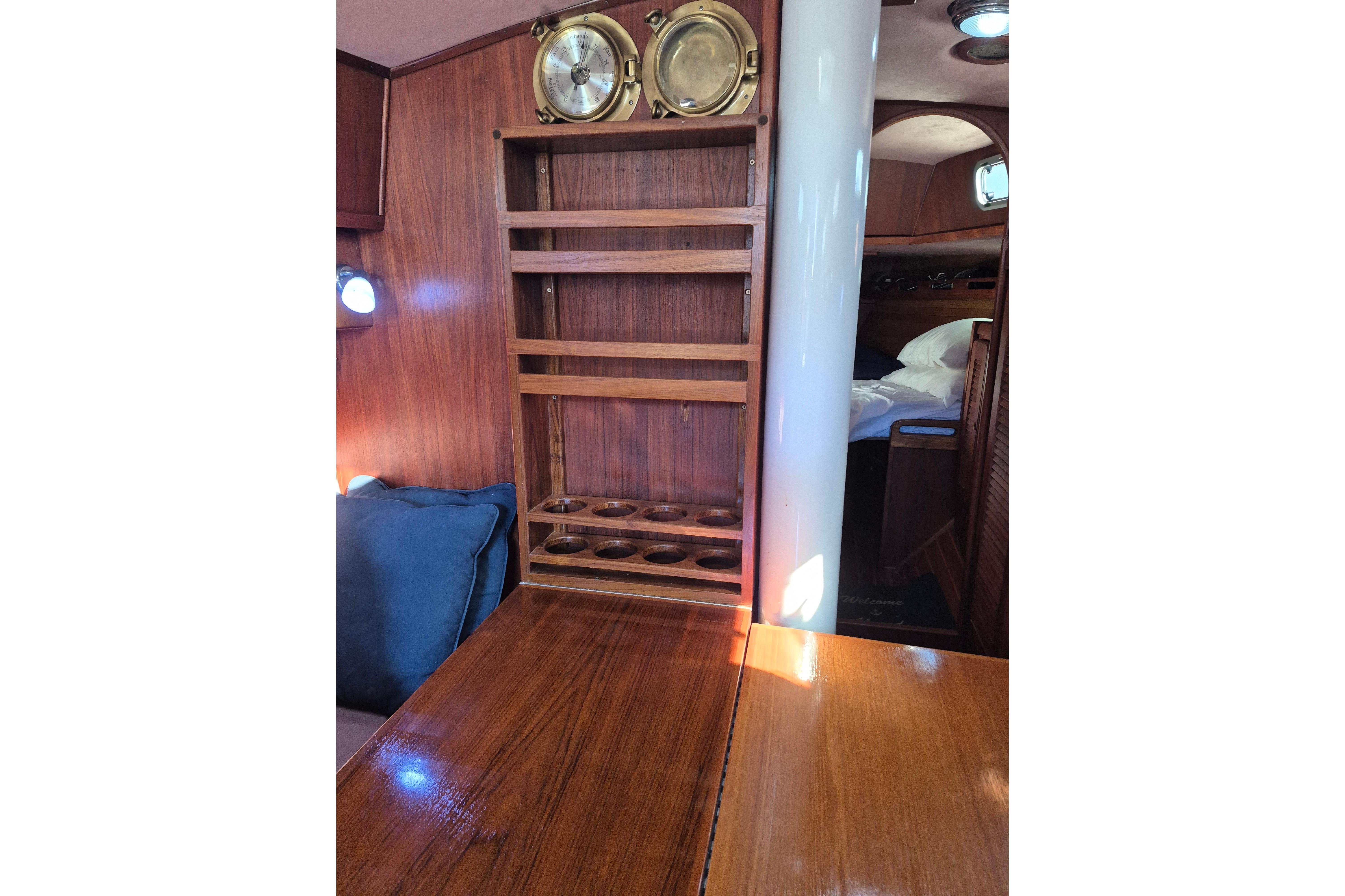 Interior of 1987 Morgan 384 sailboat with wooden shelves and nautical decor.