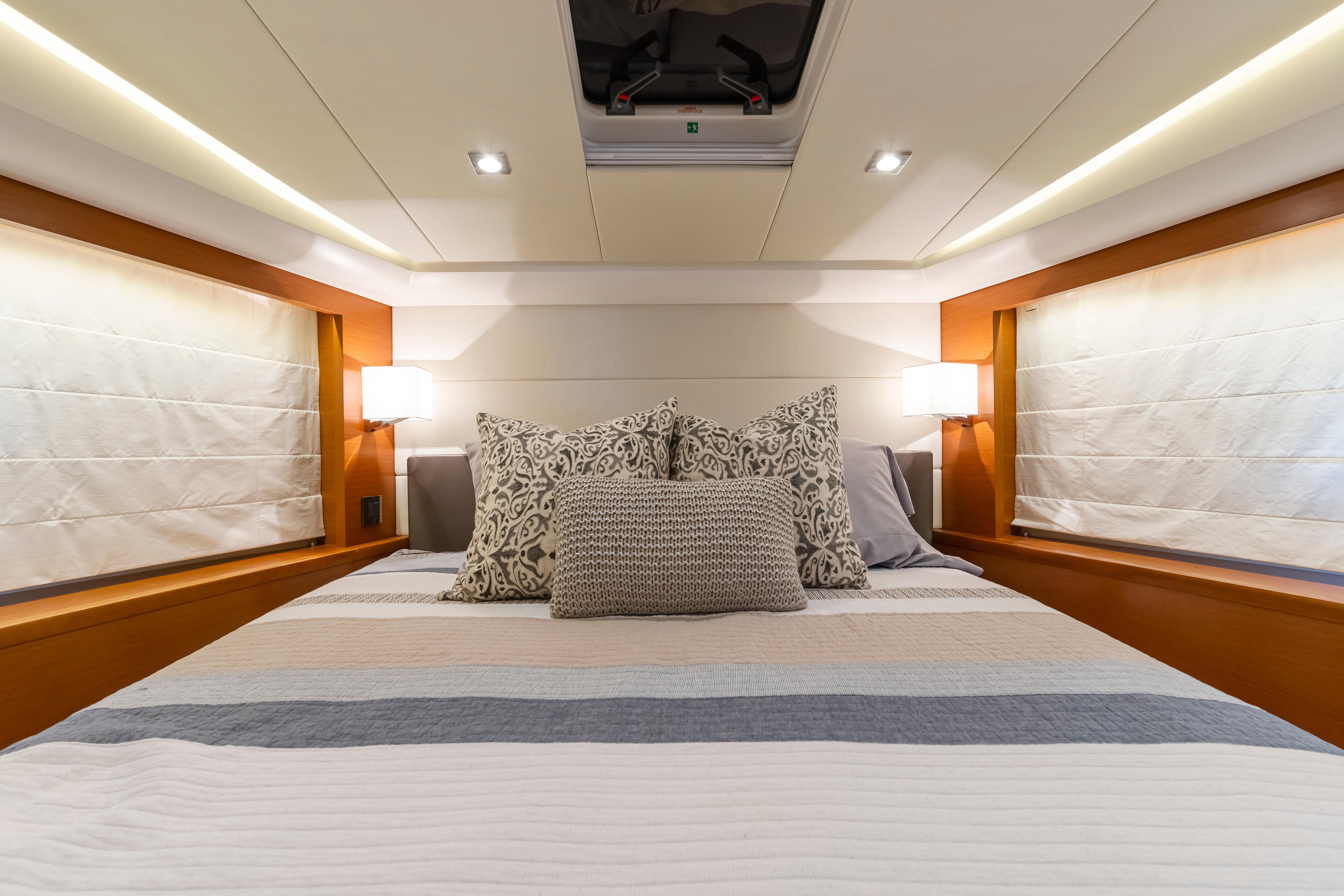 Luxurious bedroom interior of 2017 Prestige 500 yacht with elegant bedding and ambient lighting.