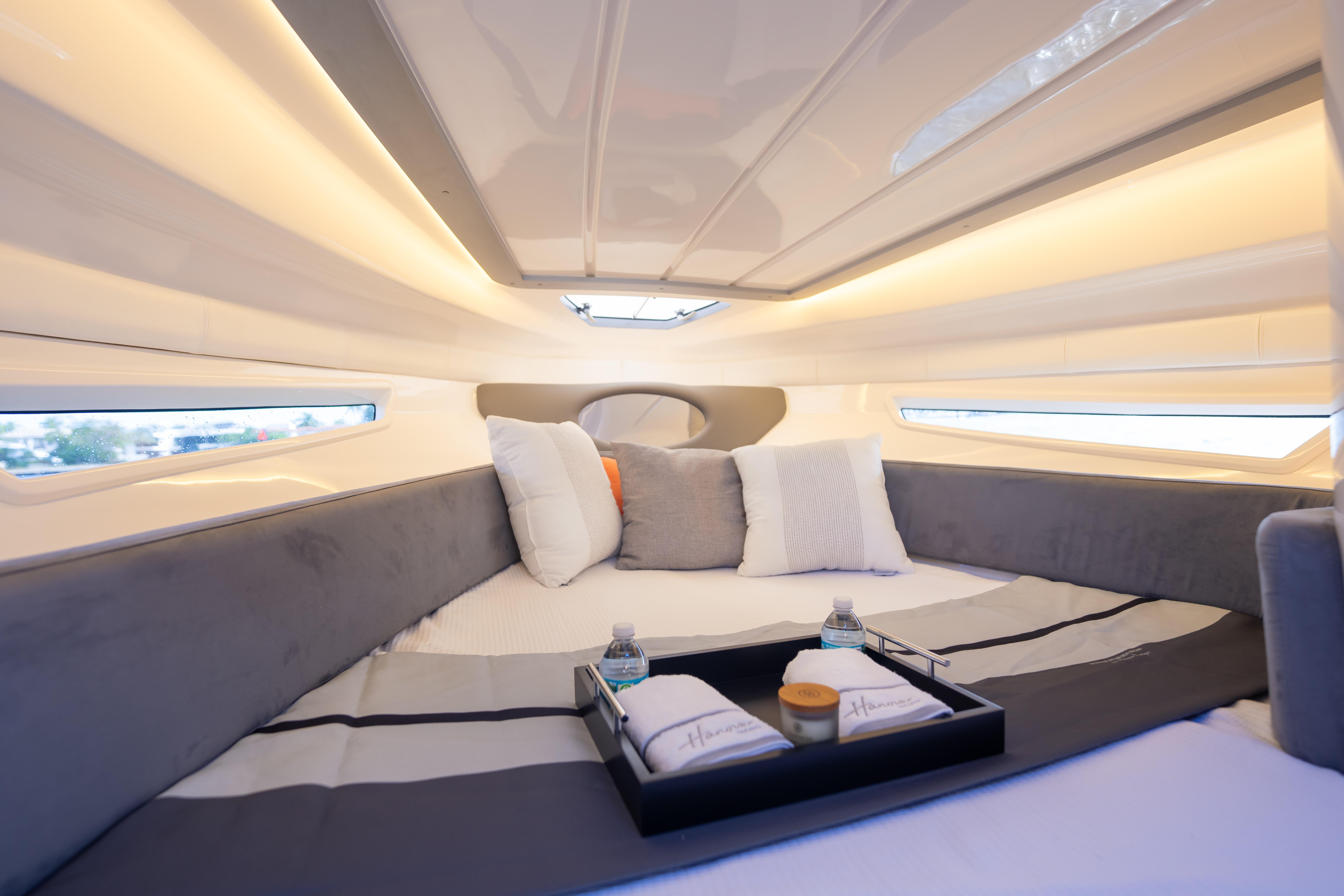 Luxurious interior of 2026 Hanover 305 yacht with cozy bedding and ambient lighting.