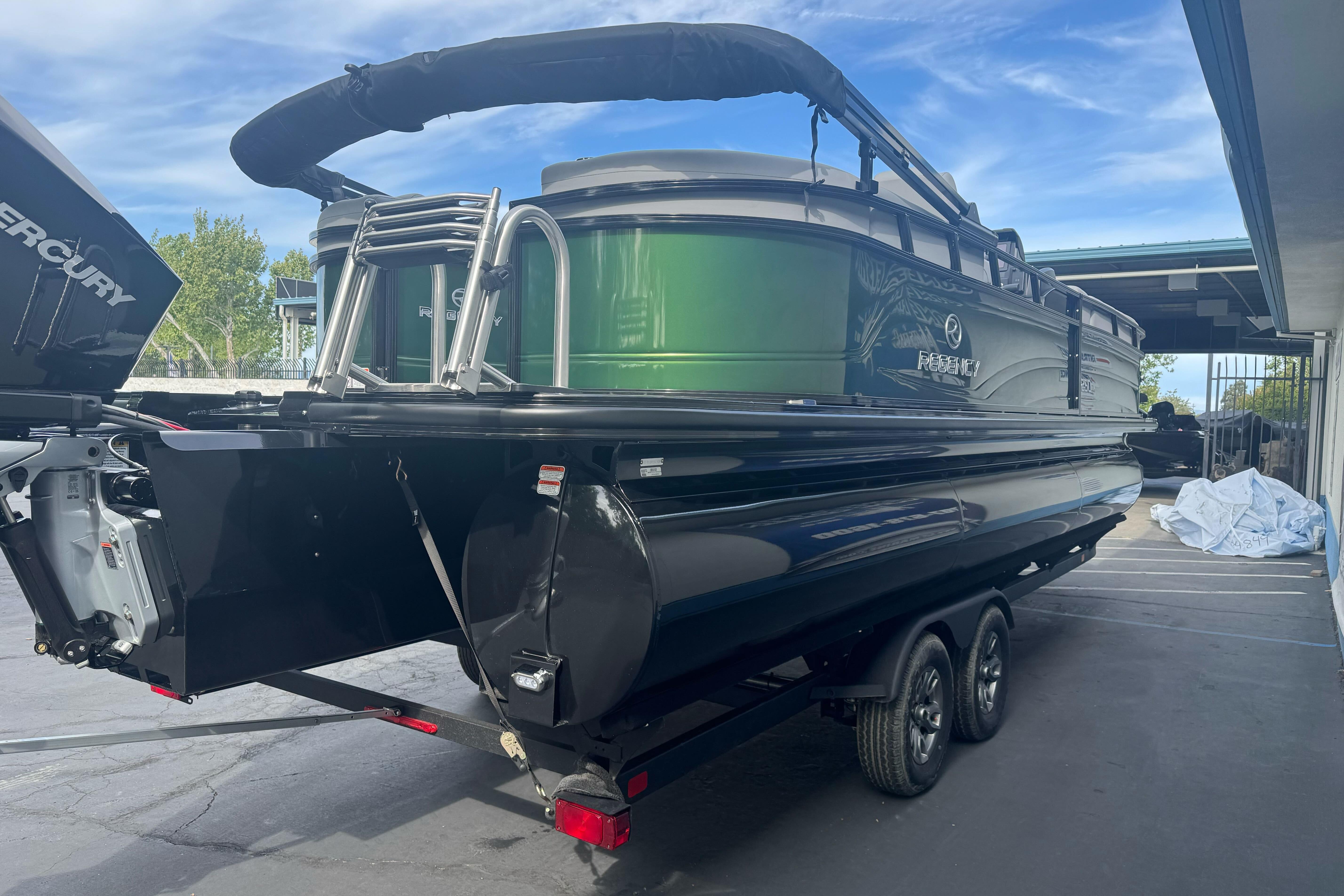 2026 Regency 250 DL pontoon boat on trailer, featuring green and black design.