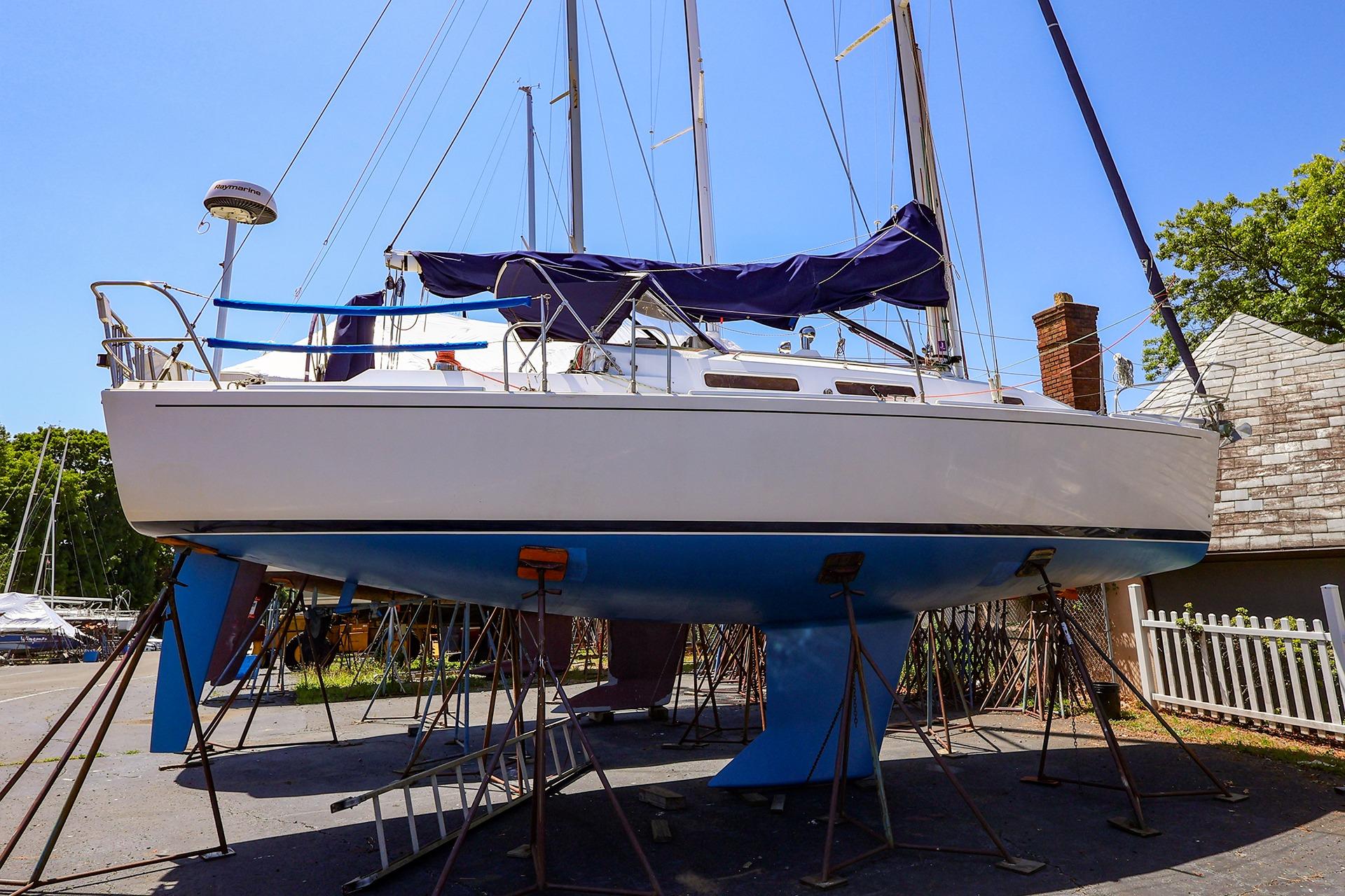 2001 J Boats J/32 sailboat on stands, blue hull, outdoor setting.